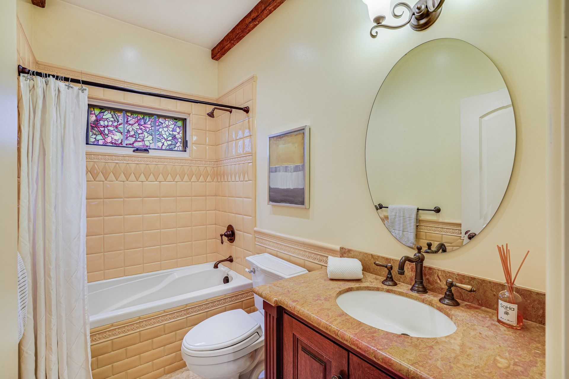 A bathroom with a toilet , sink , tub and mirror.