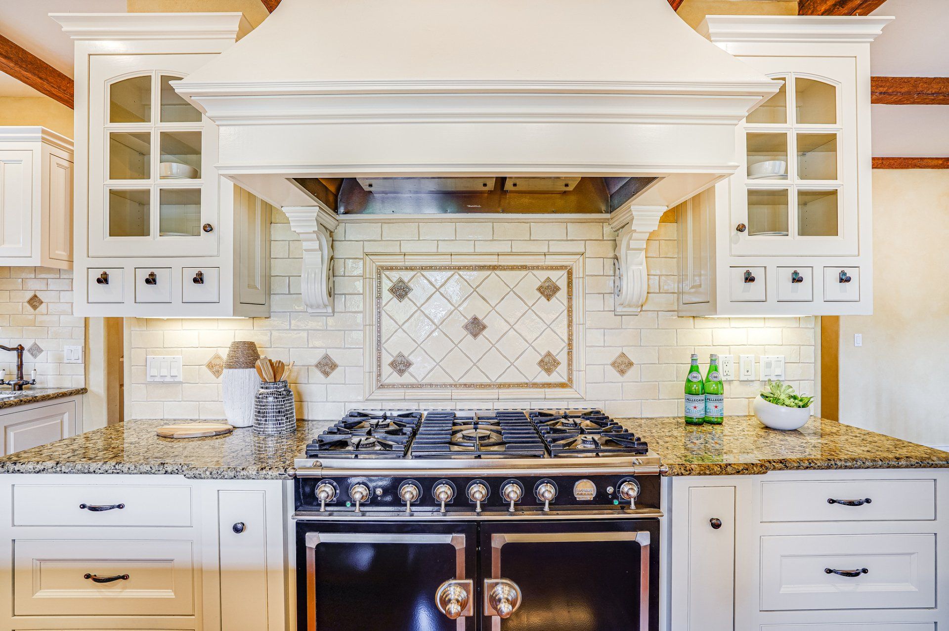 A kitchen with a stove and a hood above it.