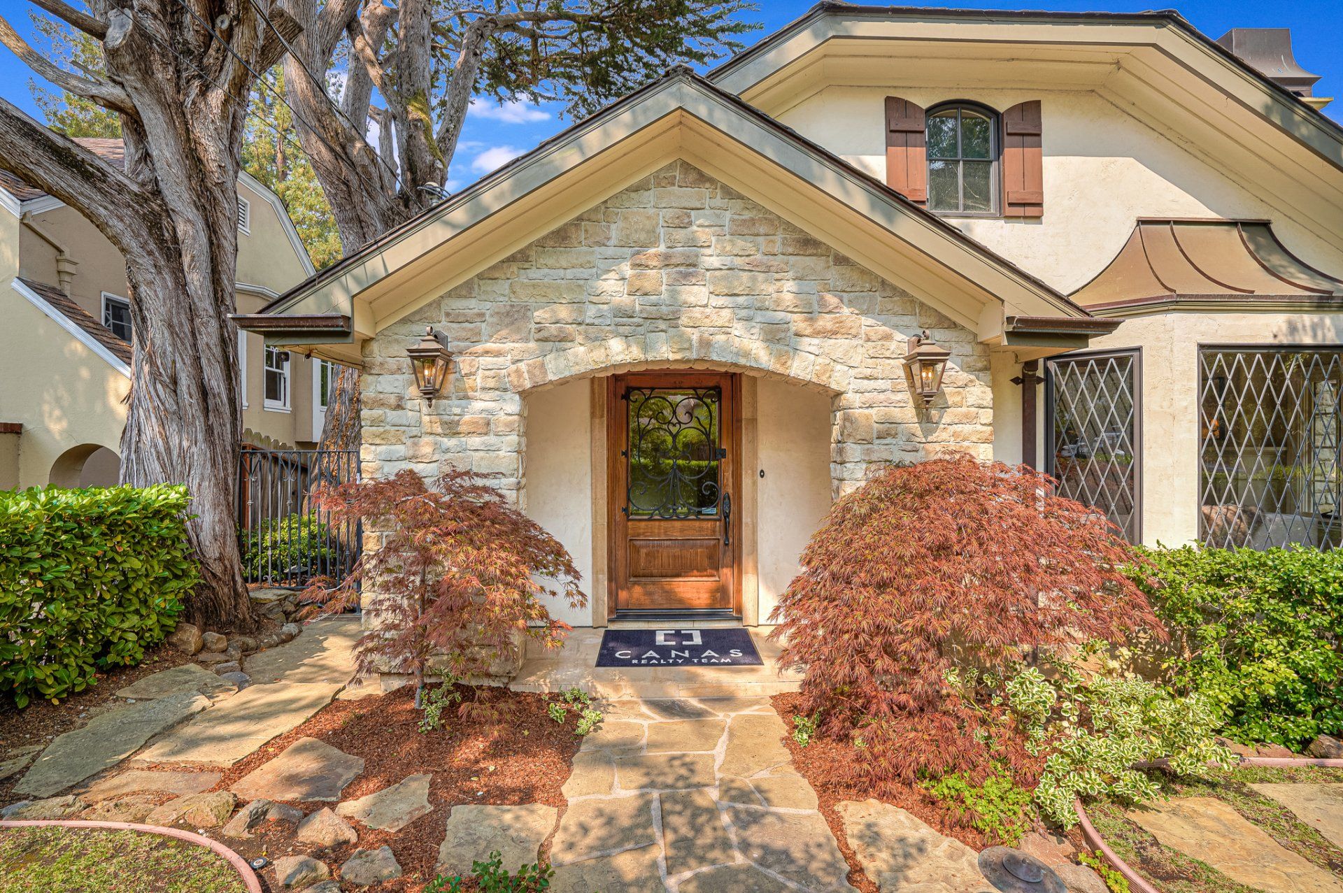 A large white house with a stone facade and a wooden door.