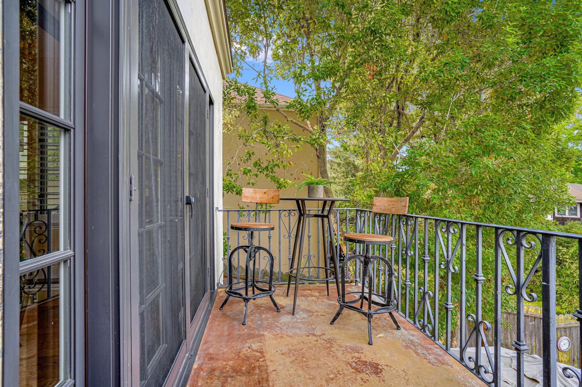 There is a balcony with a table and chairs on it.