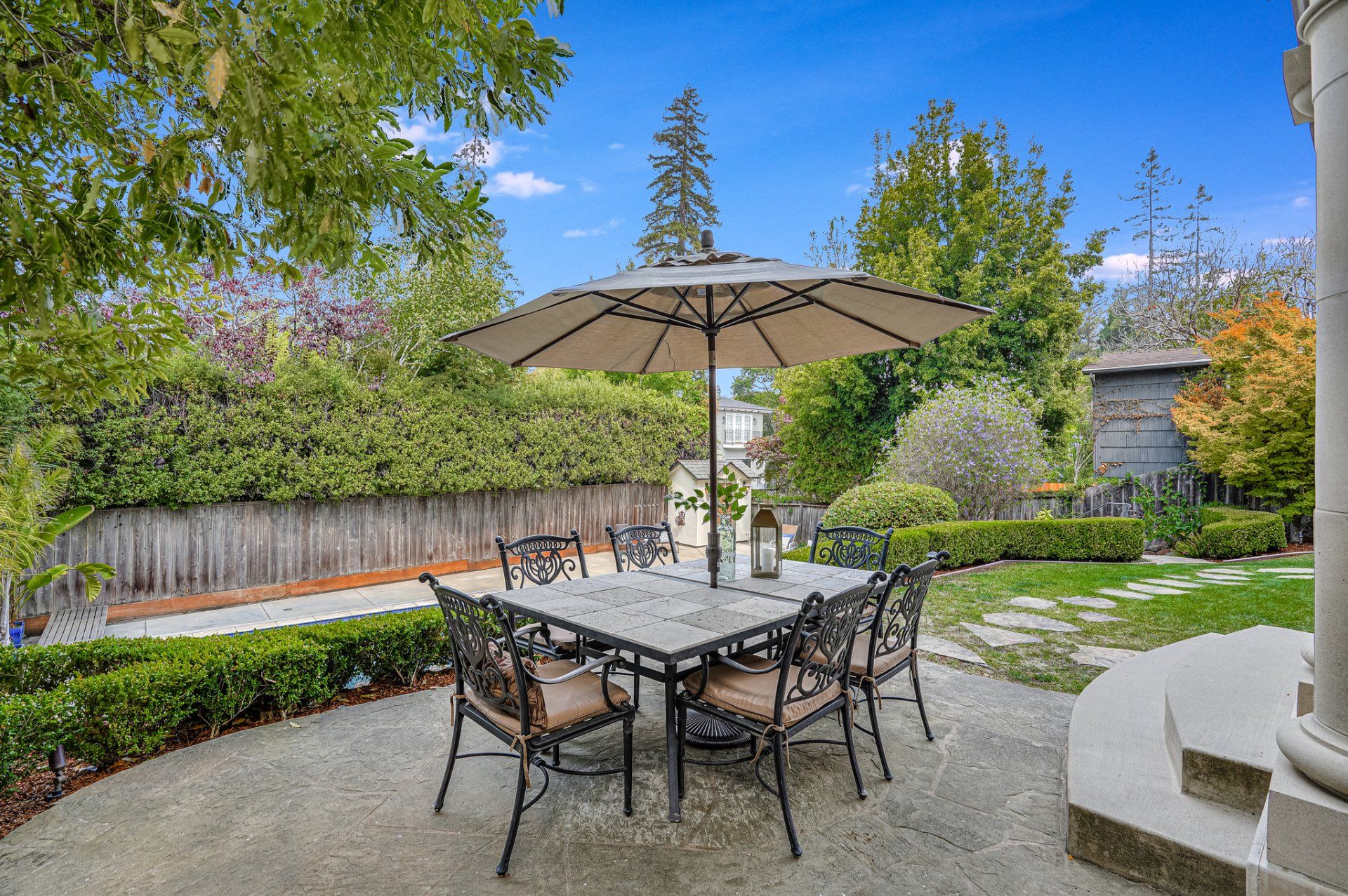 A patio with a table and chairs and an umbrella.