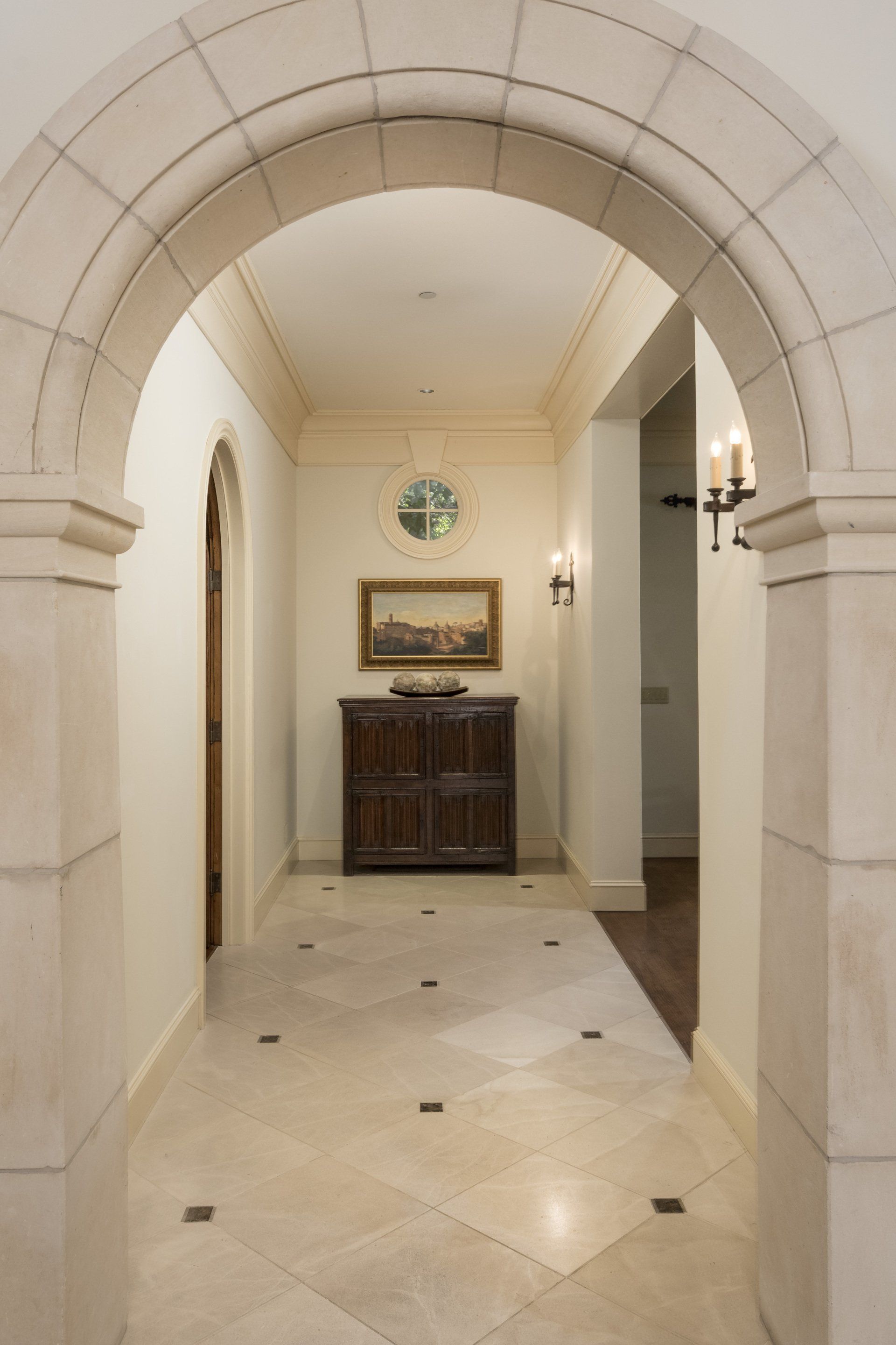 A hallway with arches and a painting on the wall