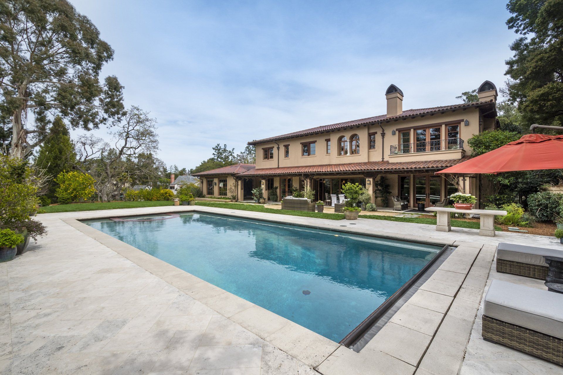 A large house with a large swimming pool in front of it
