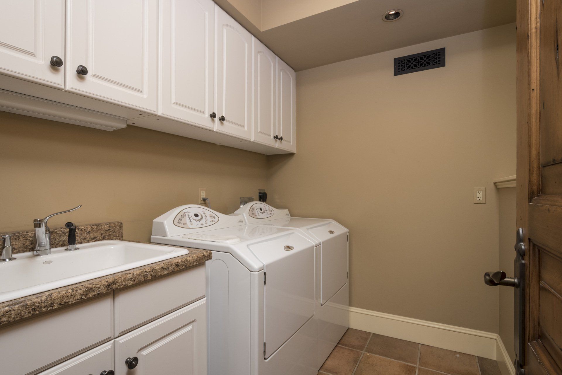 A laundry room with a washer and dryer and a sink