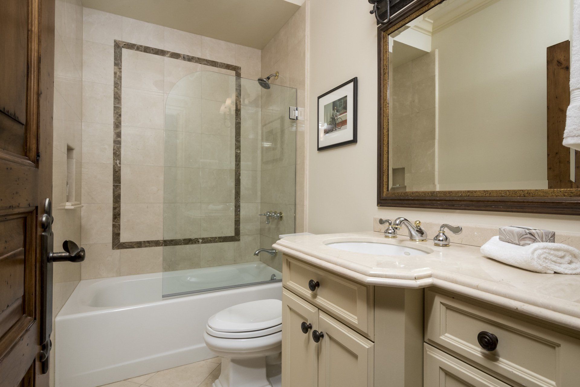 A bathroom with a toilet , sink , tub and mirror.