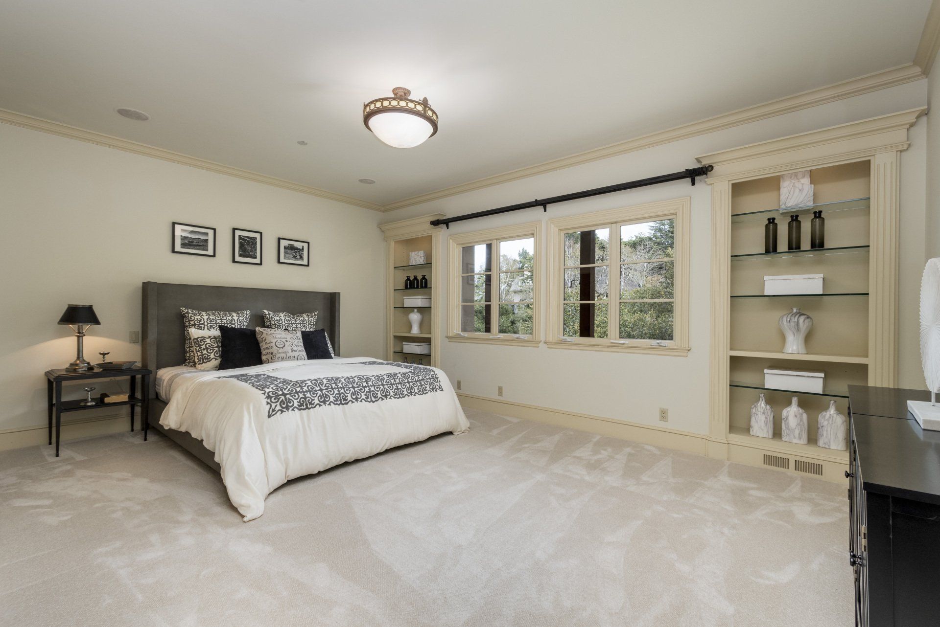 A bedroom with a large bed and lots of windows