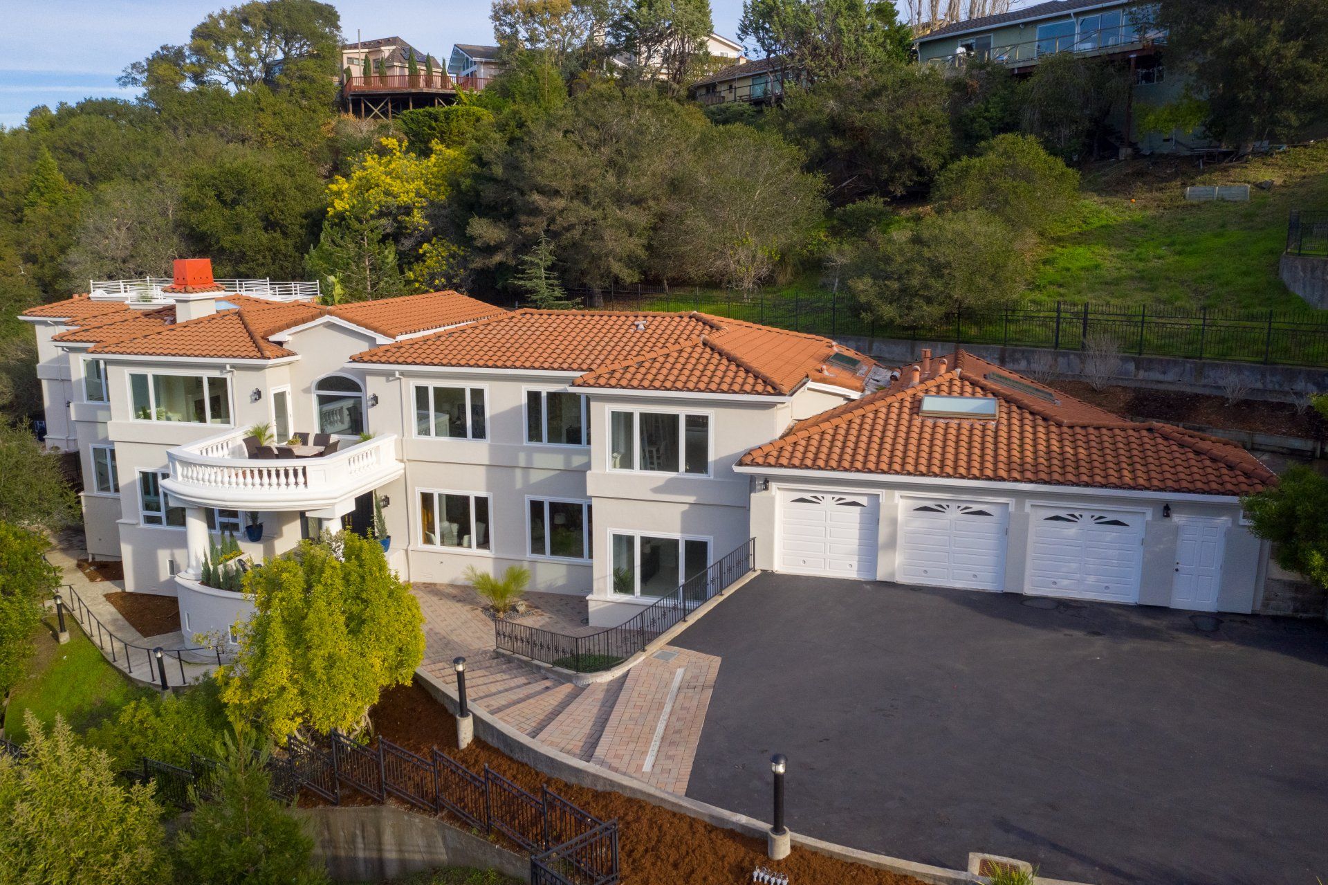 Large house with orange-tiled roof and car garage.