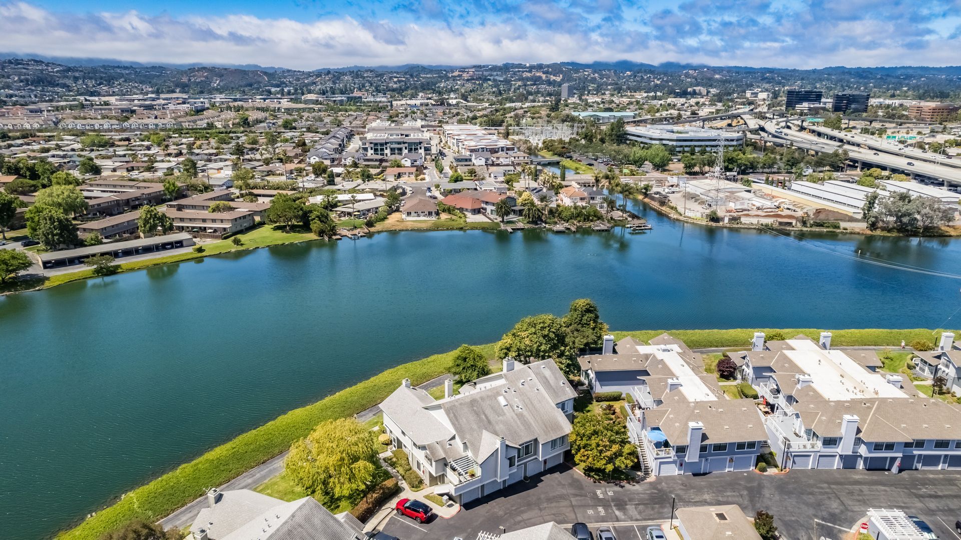 An aerial view of a body of water with houses in the foreground and a city in the background.