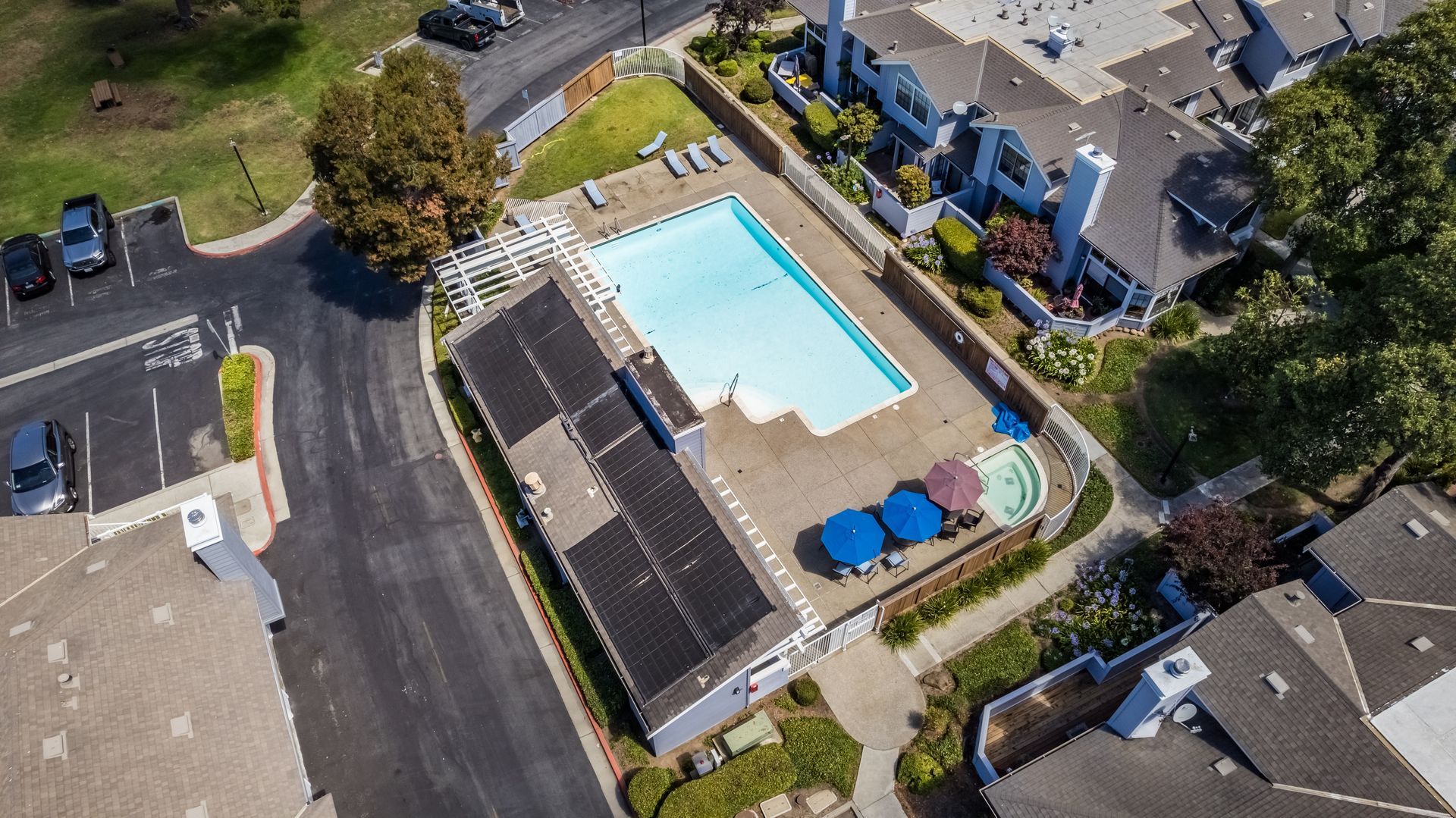 An aerial view of a swimming pool surrounded by houses.