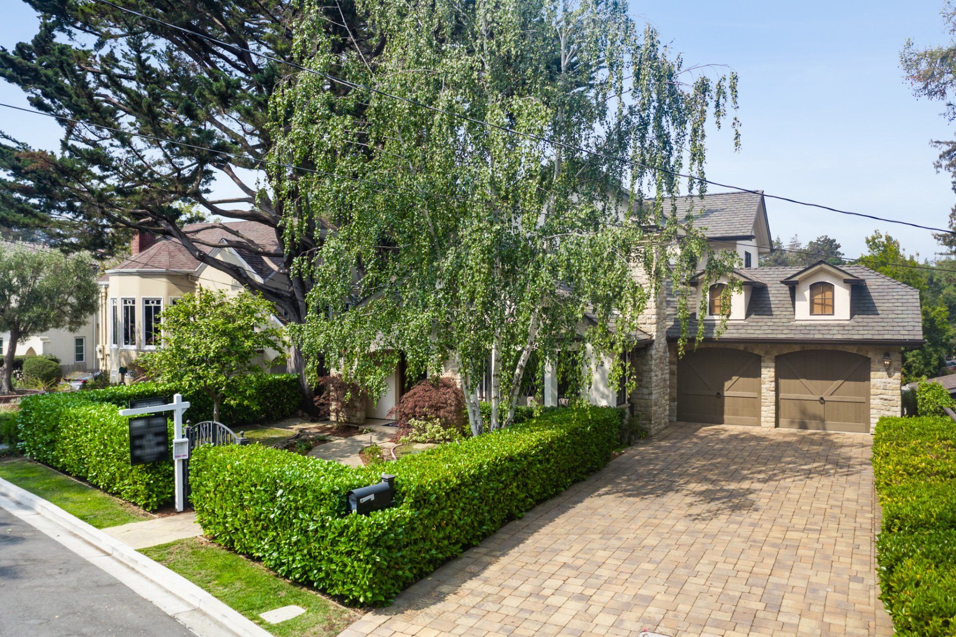 A brick driveway leading to a house with a garage