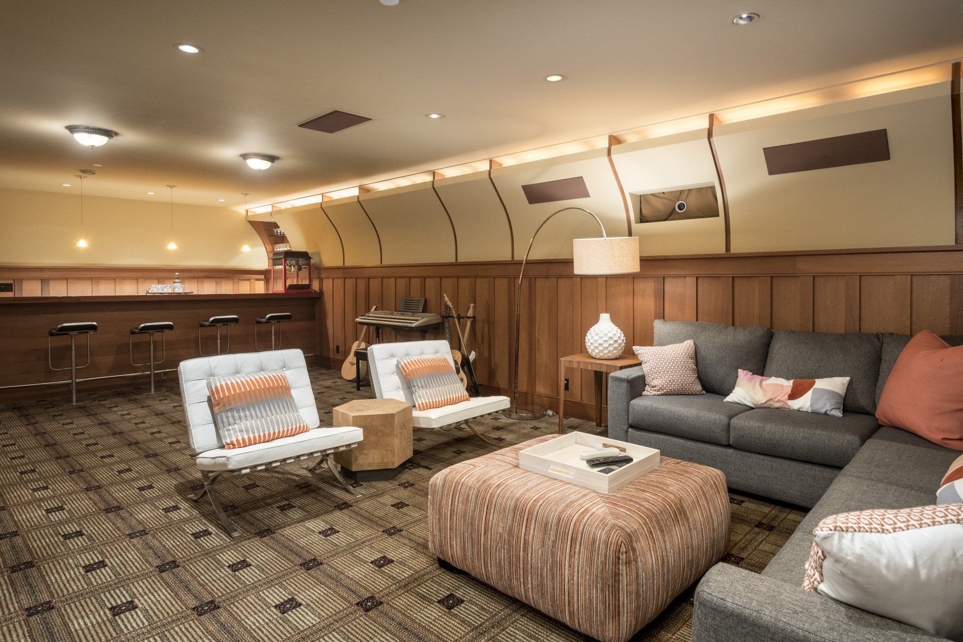 A room with a couch , chairs , and ottoman.