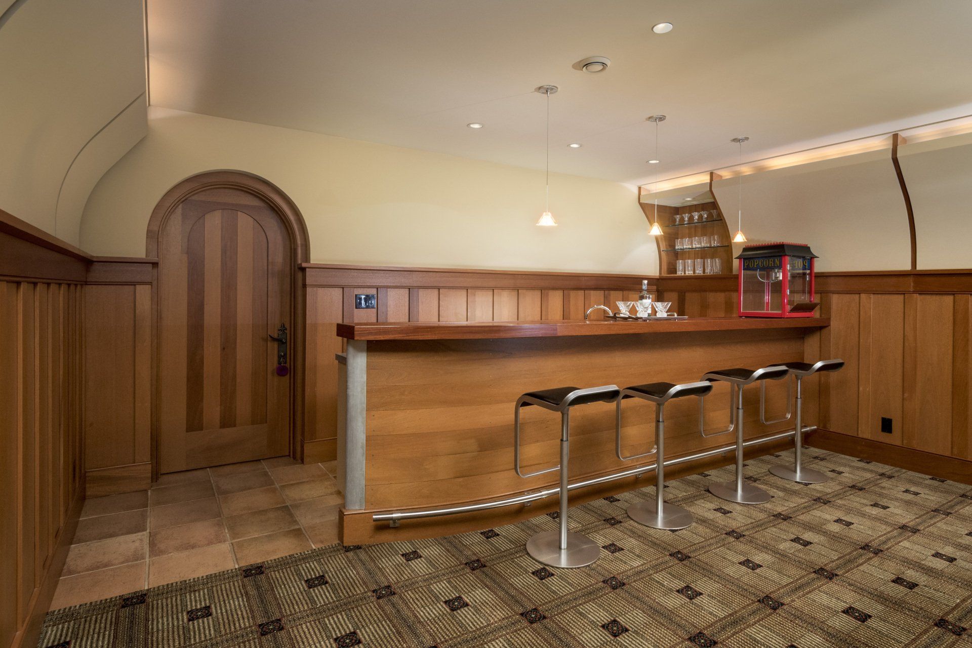 A bar in a room with wood paneling and stools