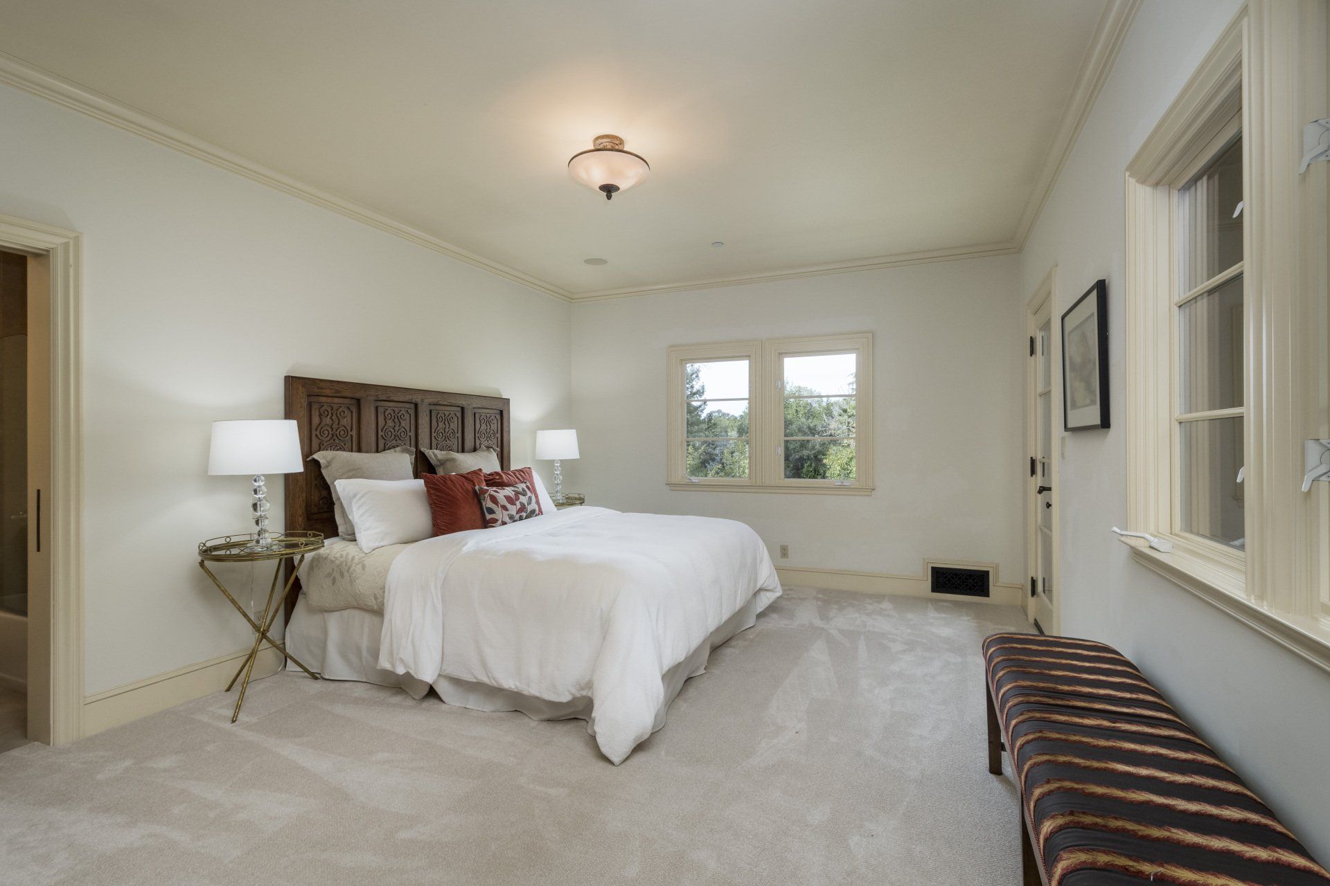 A bedroom with a large bed and a bench