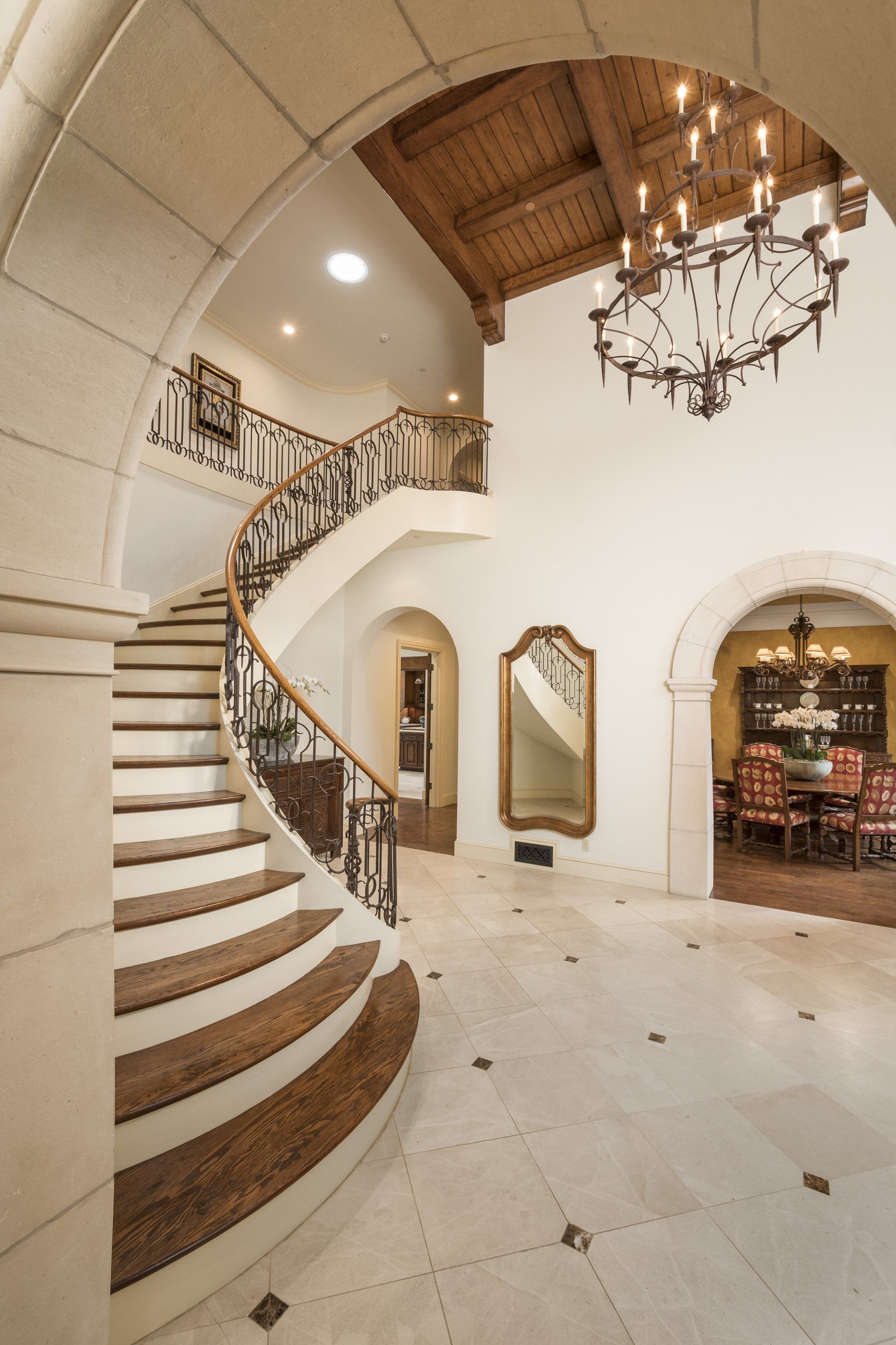 A curved staircase with a chandelier hanging from the ceiling