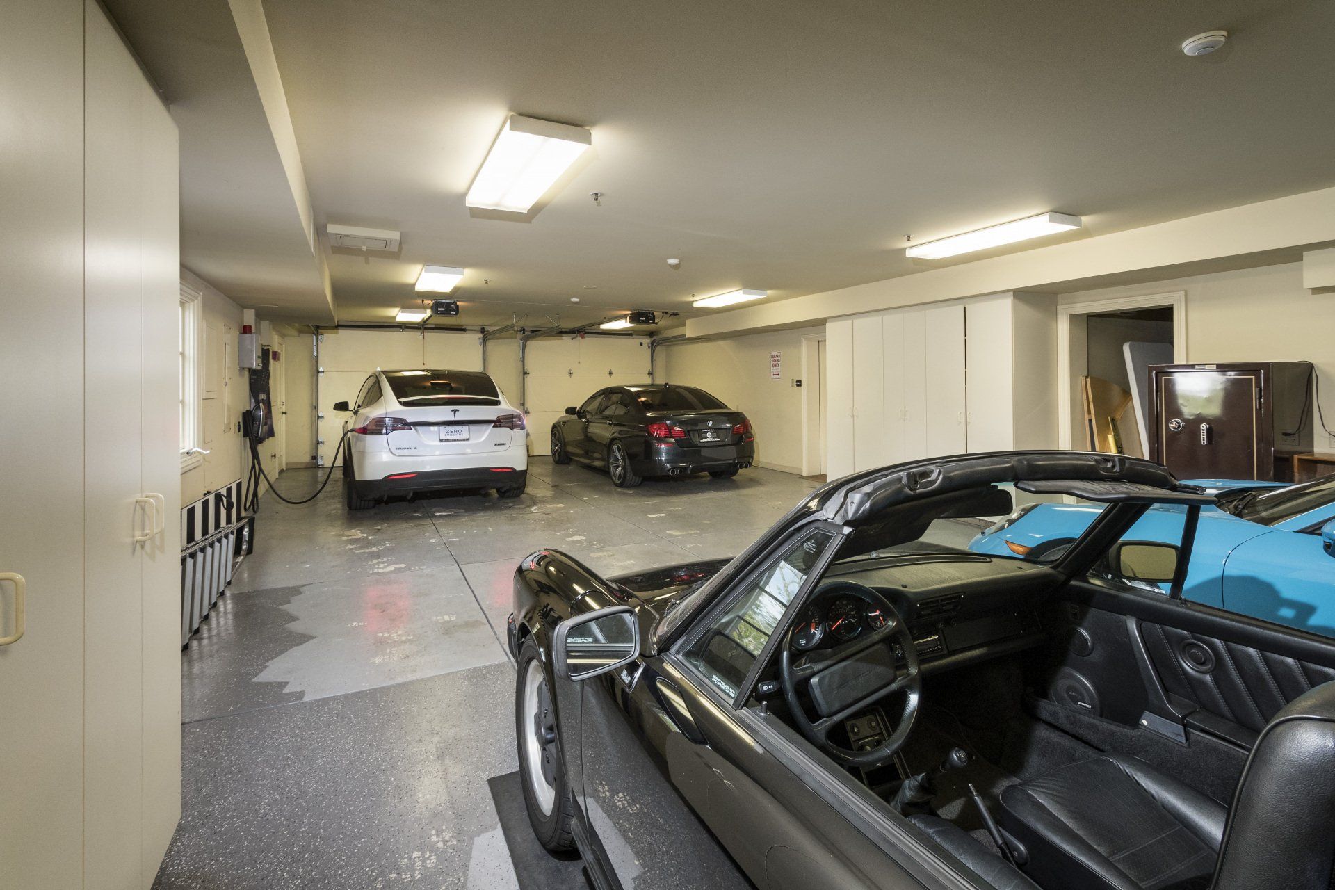 A car is parked in a garage with other cars
