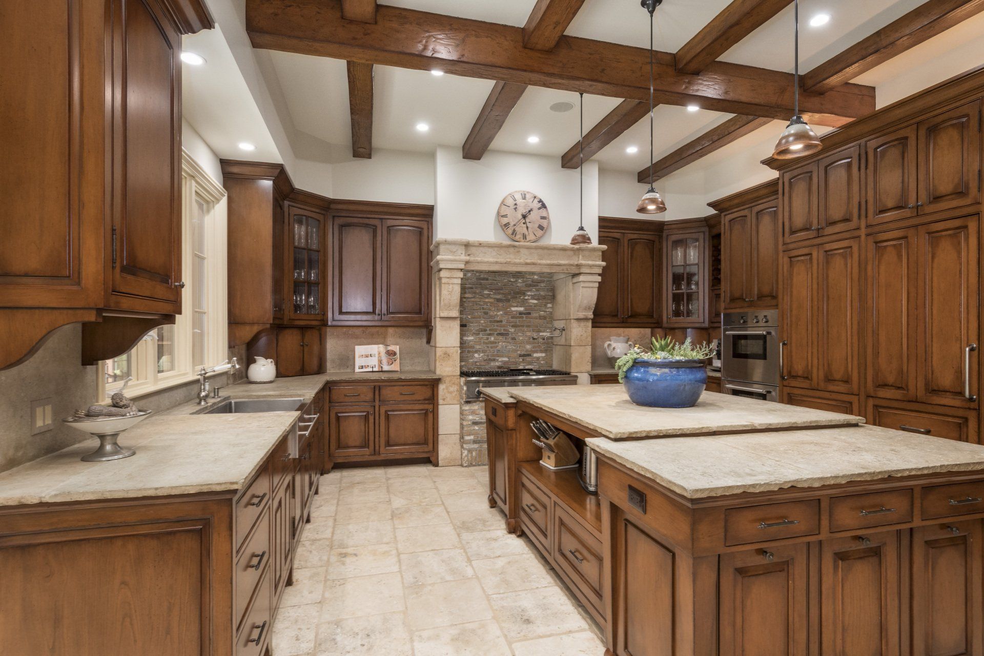 A kitchen with wooden cabinets and marble counter tops