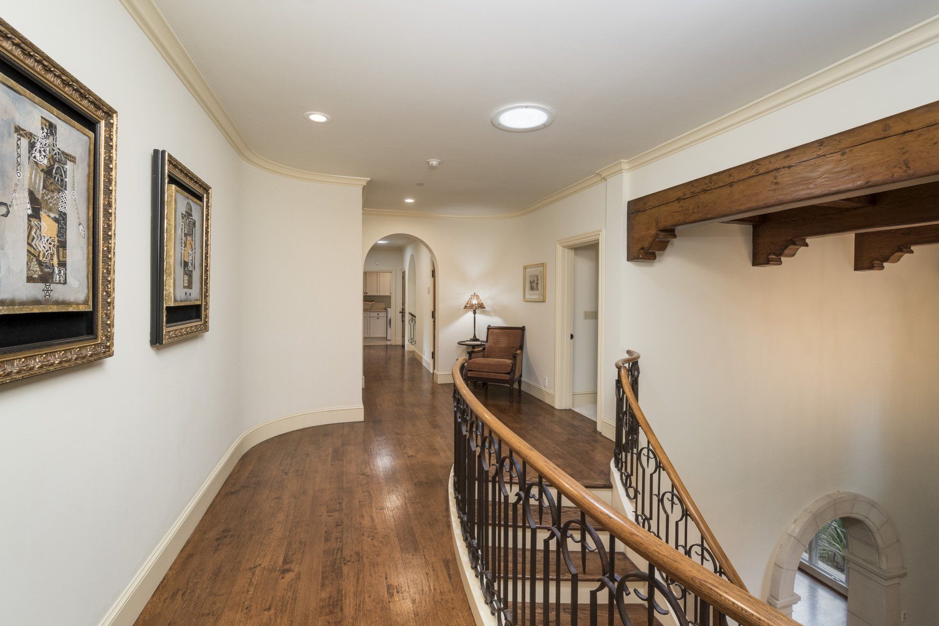 A hallway with wooden floors and stairs in a house