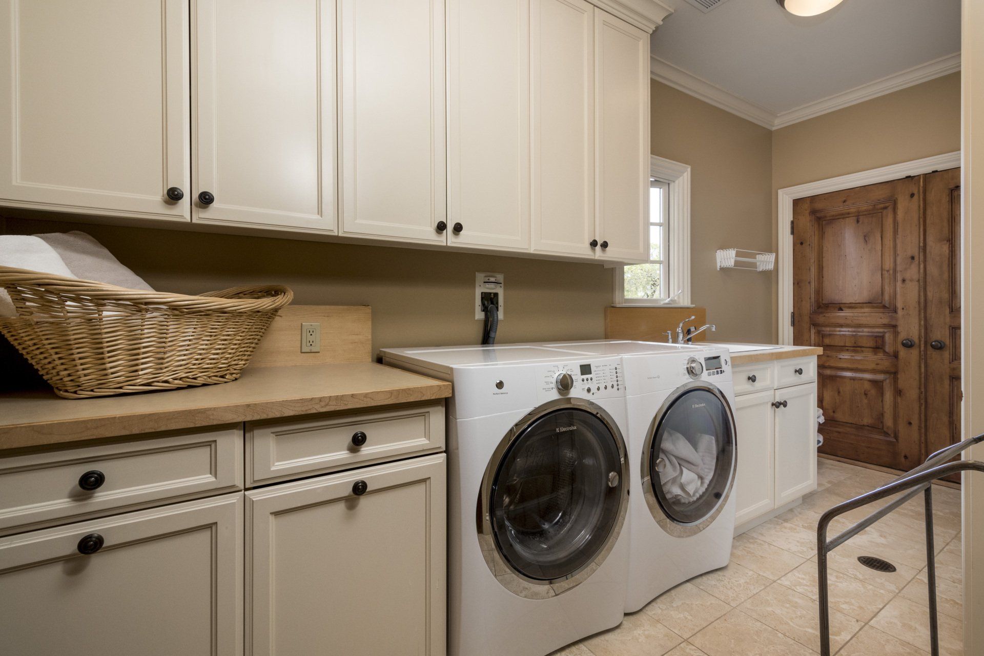 A laundry room with a washer and dryer and a basket on the counter.