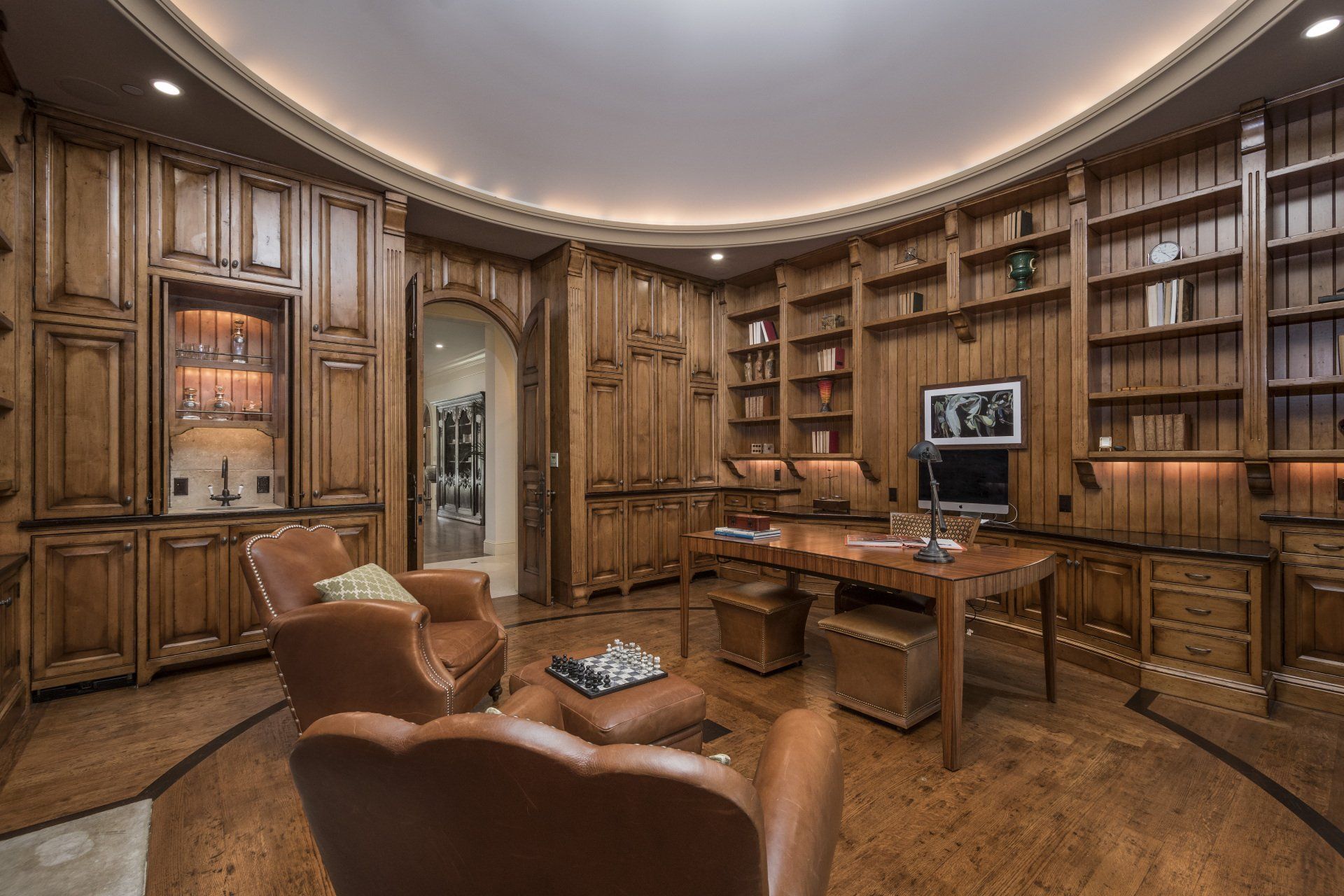 A home office with a round ceiling and lots of bookshelves