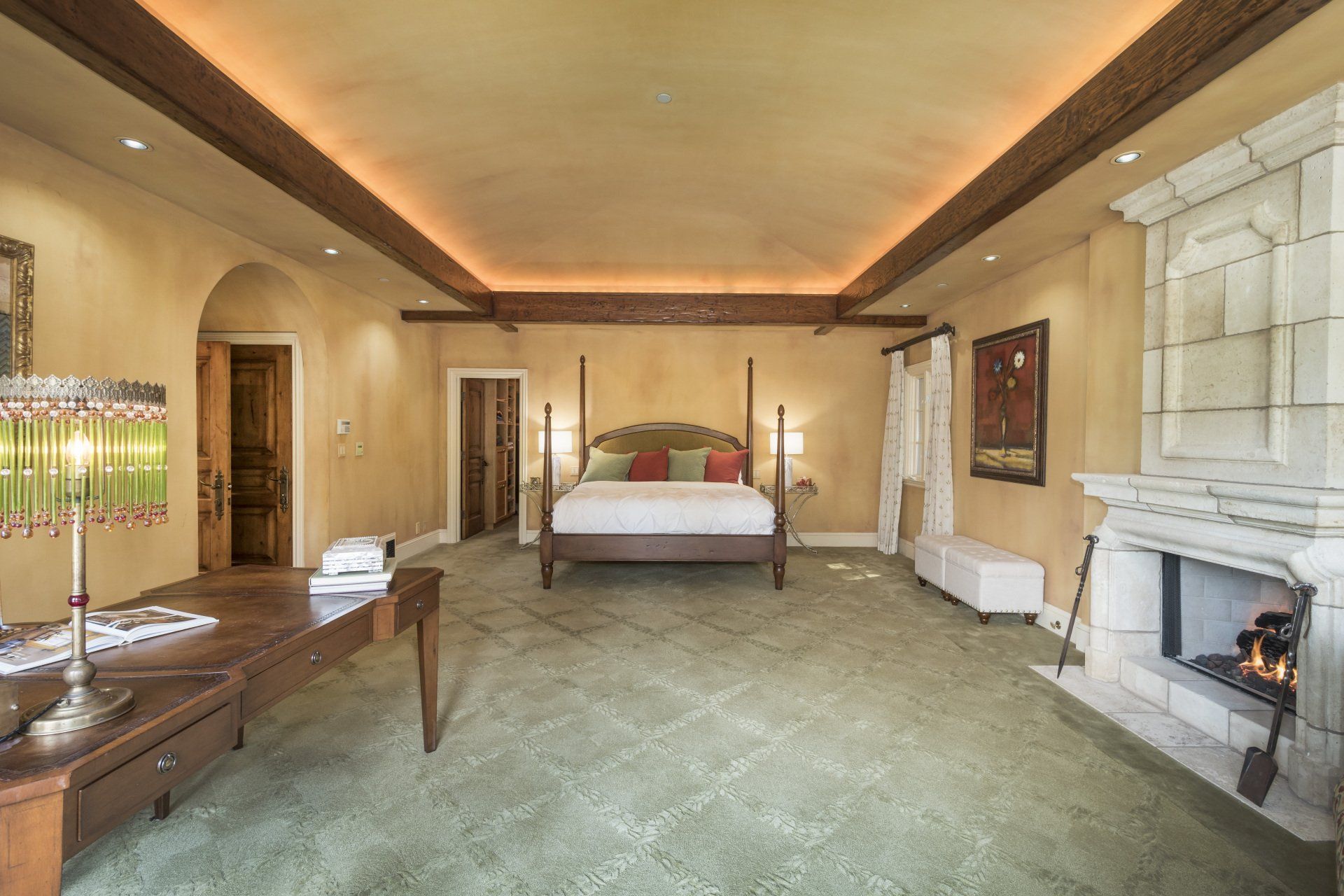 A bedroom with a four poster bed and a fireplace