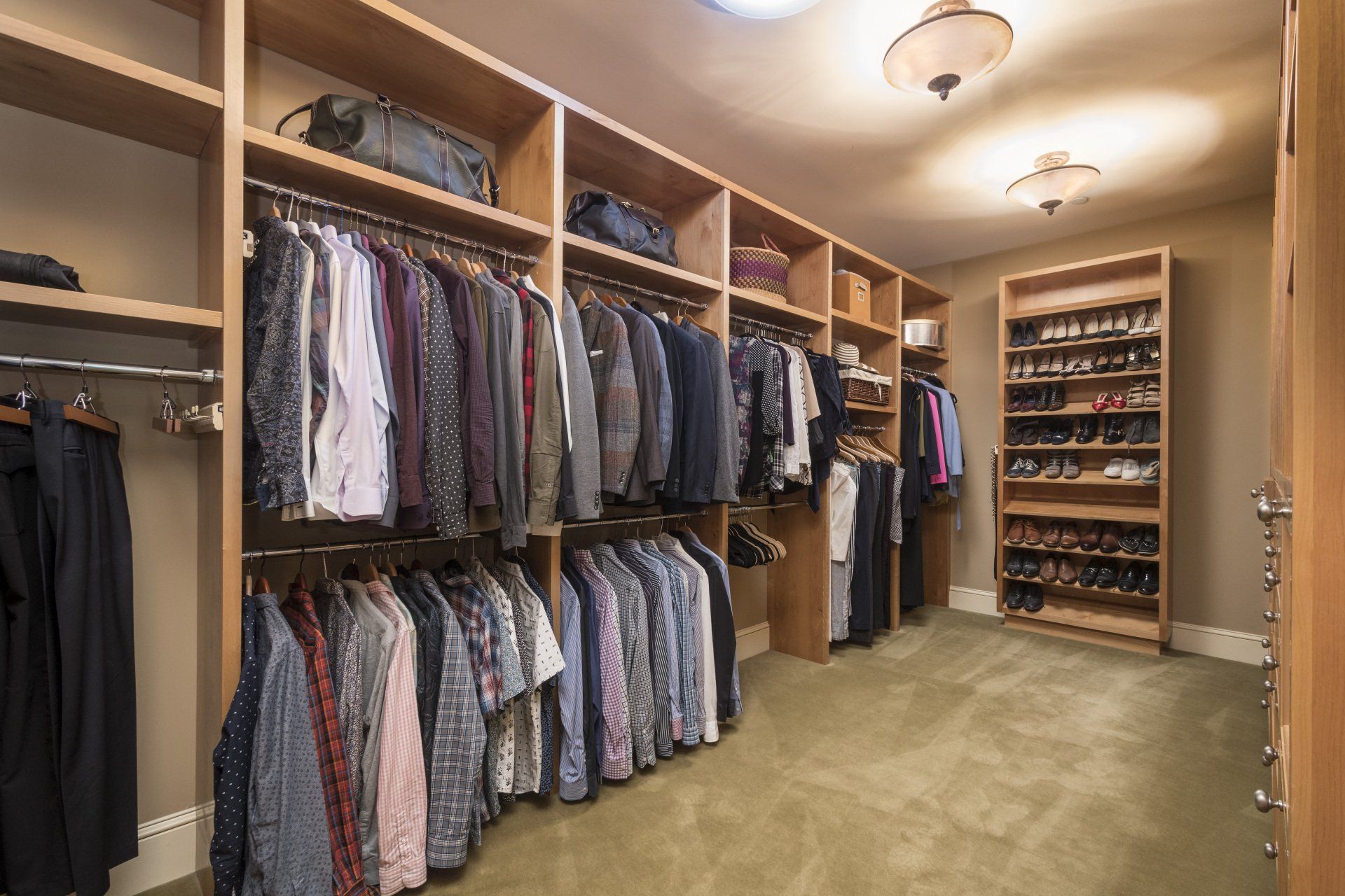 A walk in closet filled with lots of clothes and shoes.