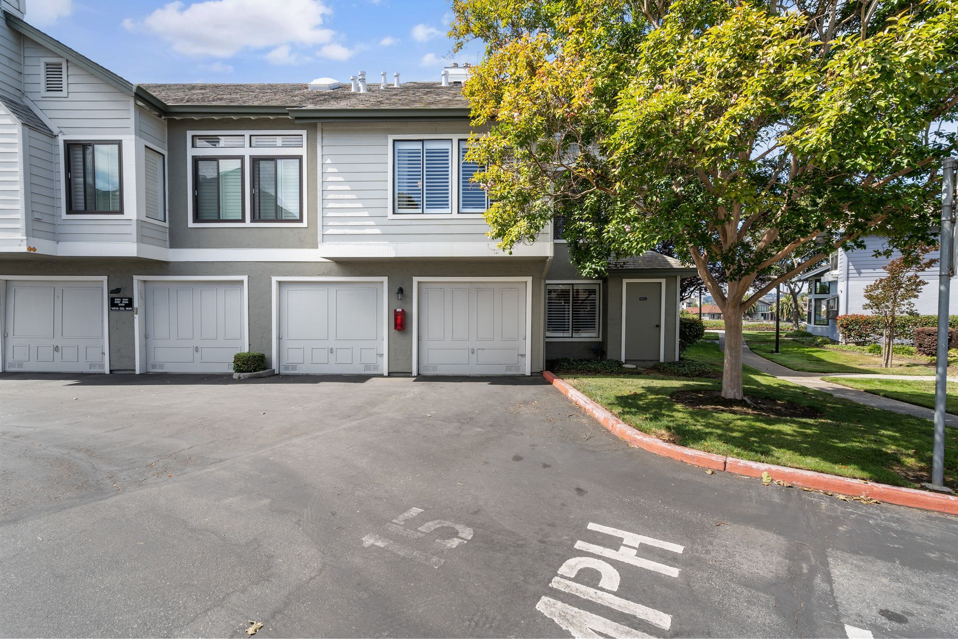 A house with a lot of garages and a parking lot in front of it.