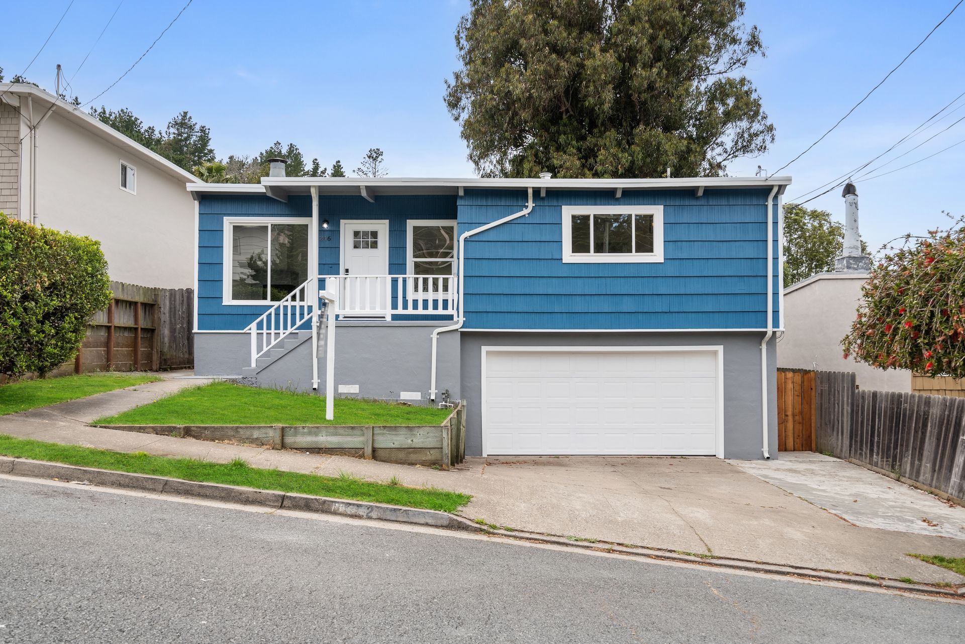 A blue and gray house with a white garage door.