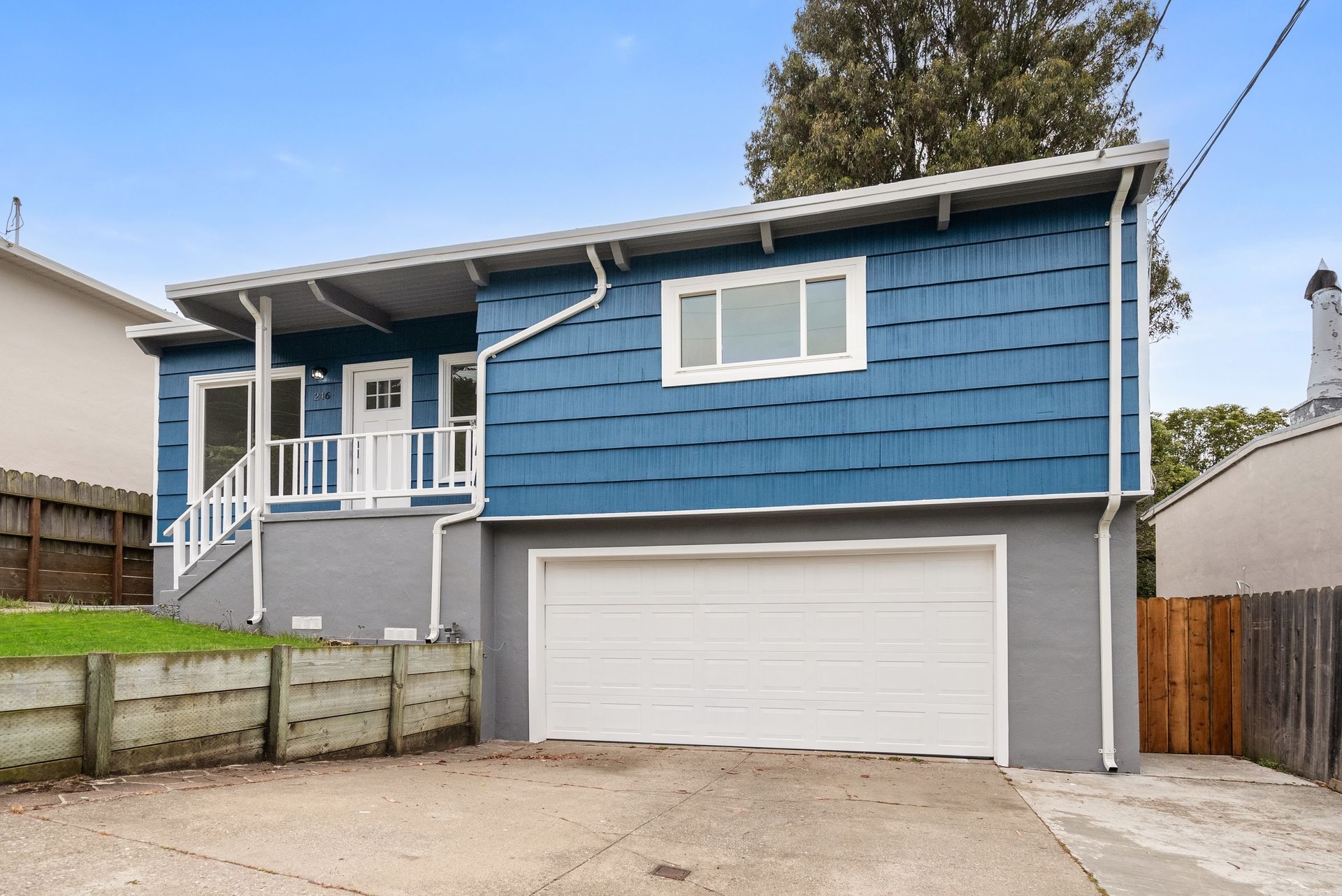 A blue and gray house with a white garage door.