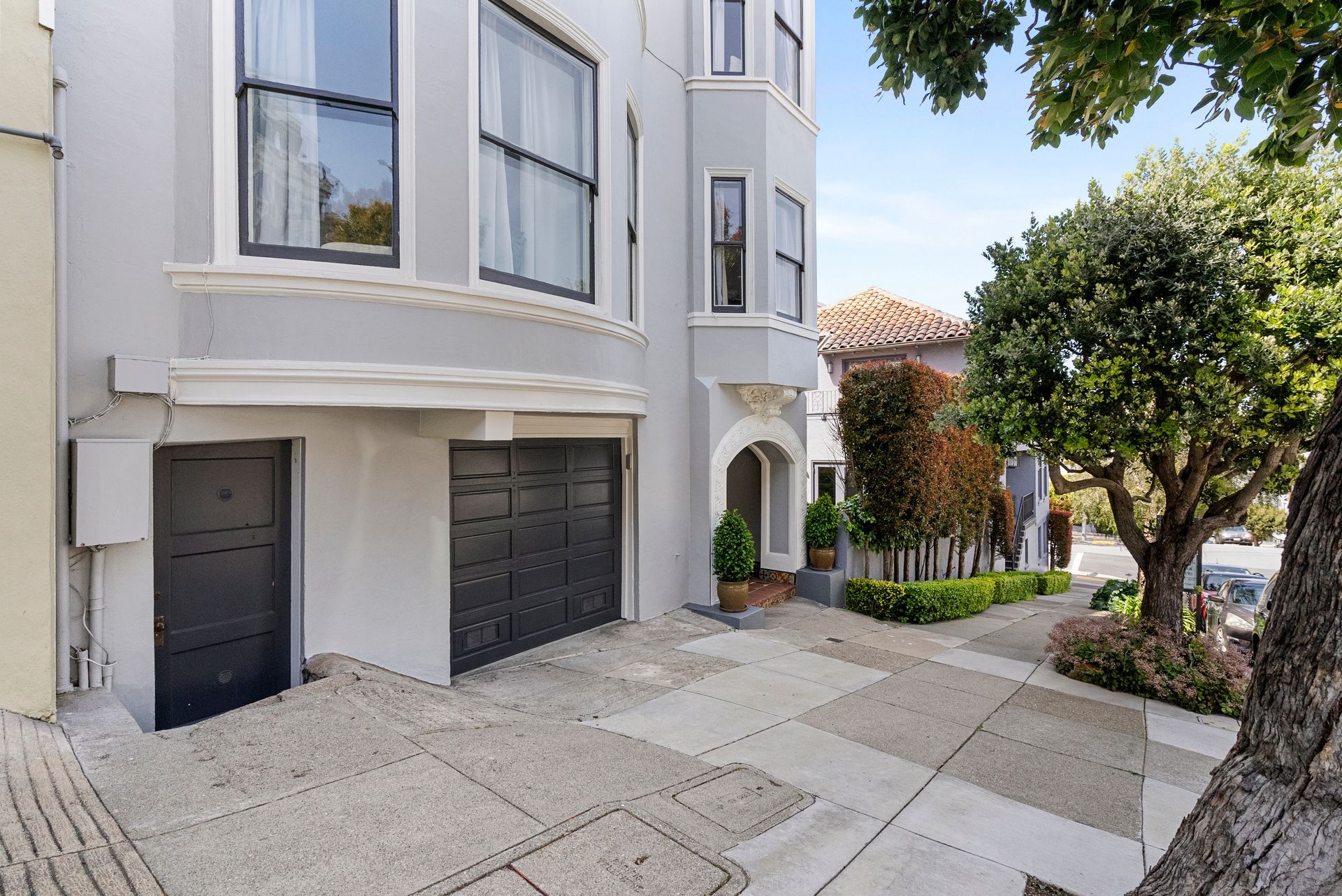 A house with garage and a tree in front of it.