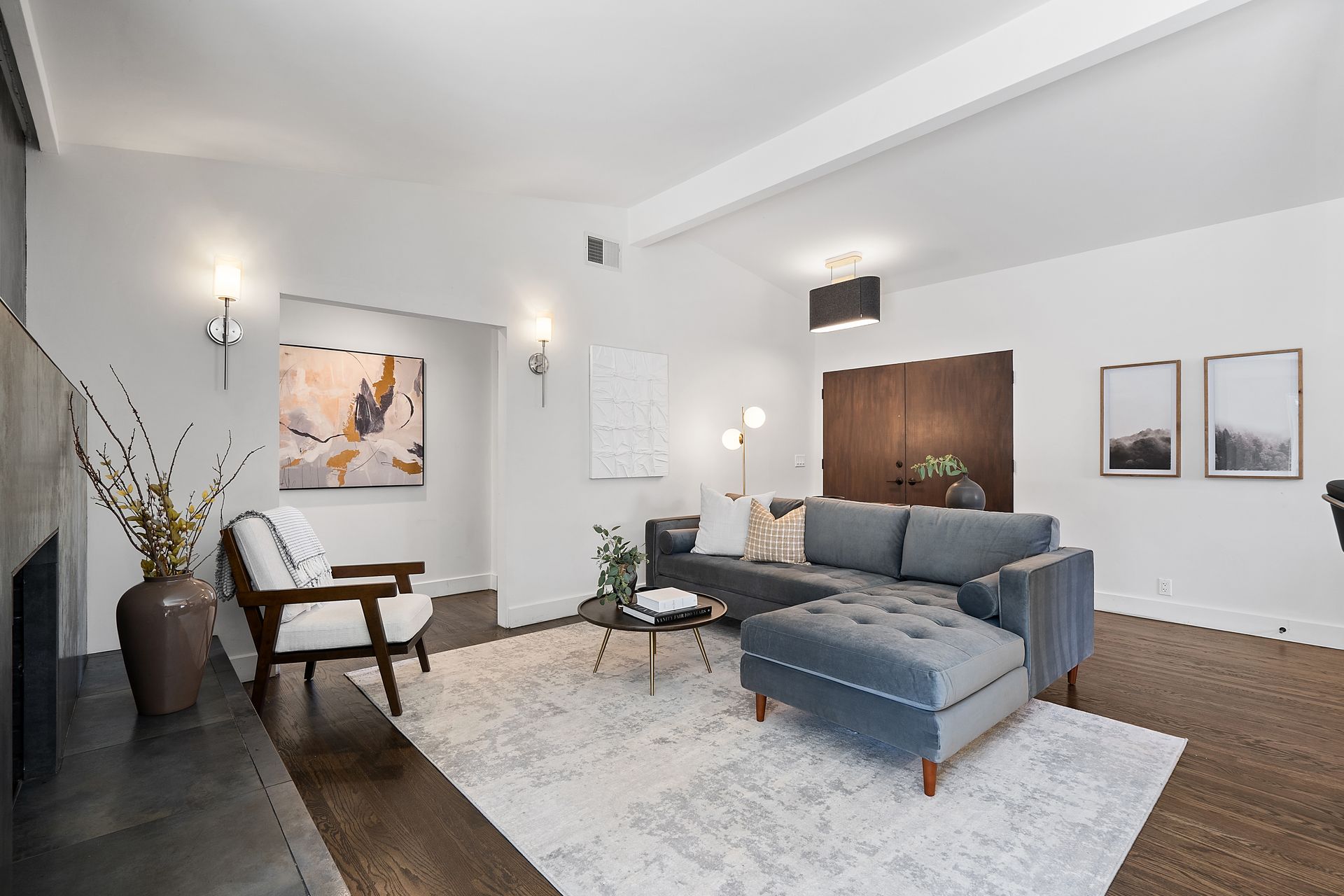 A living room with a couch , chair , coffee table and fireplace.