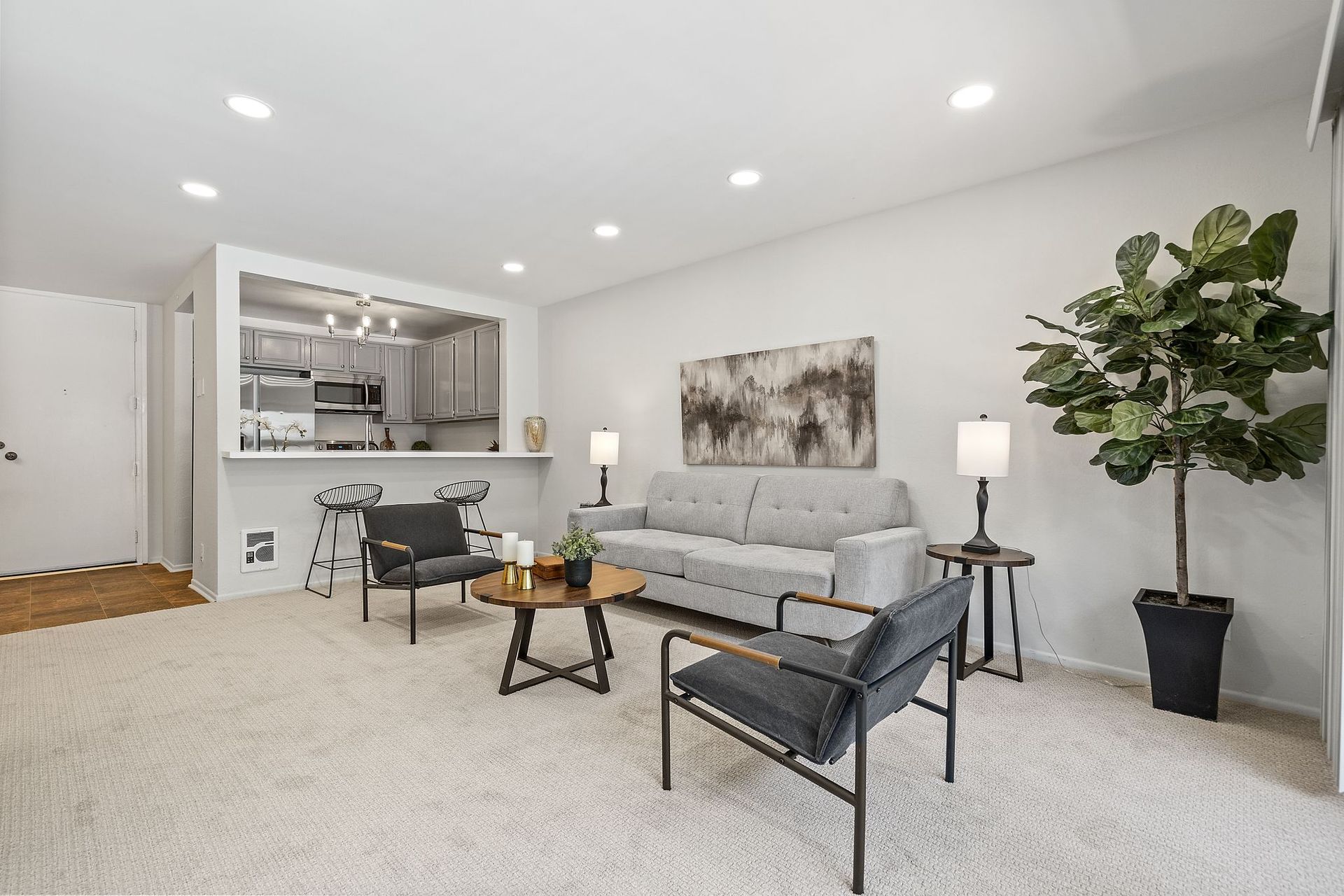 A living room with a couch and two chairs.