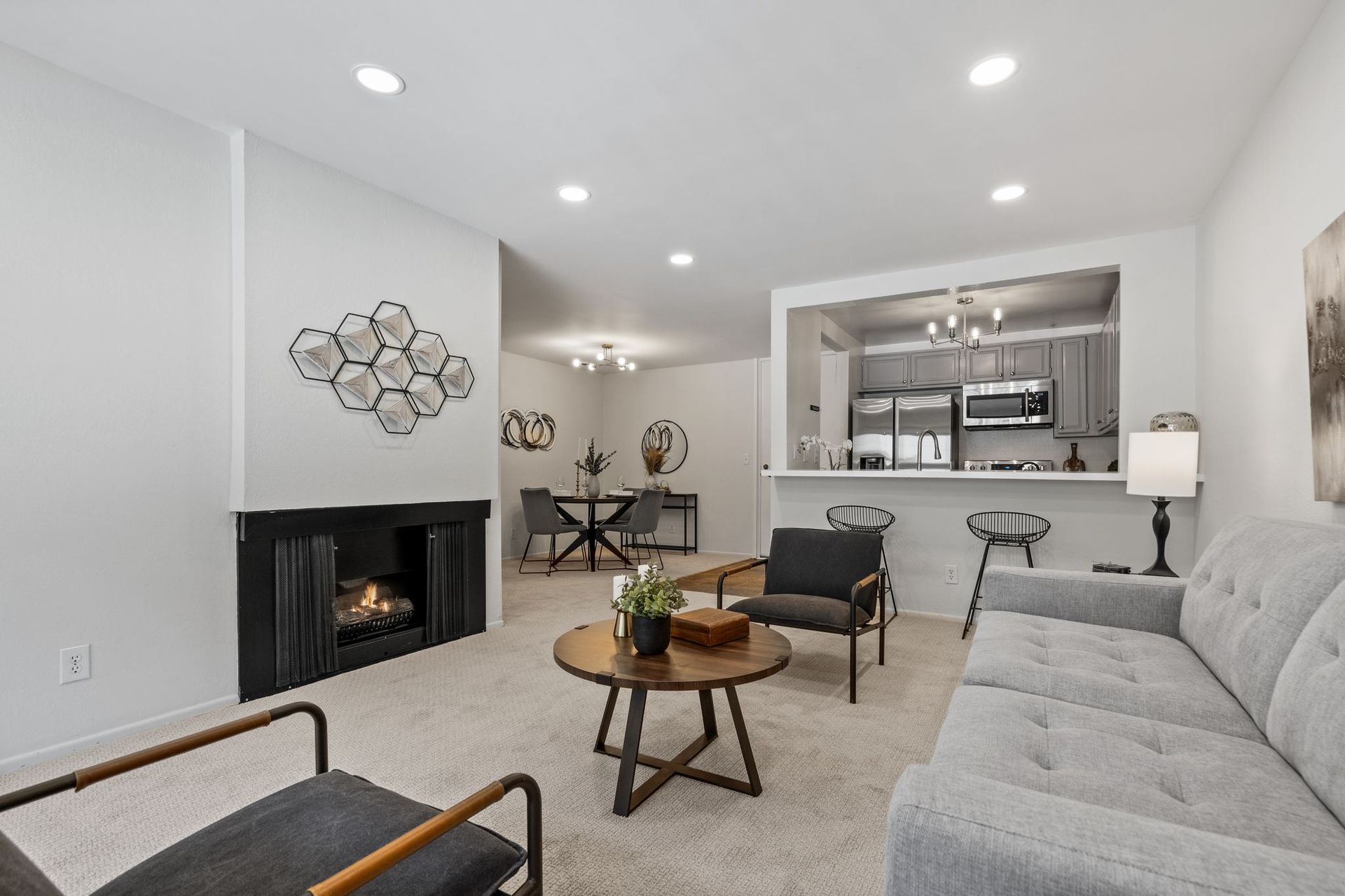 A living room with a couch and chairs and a fireplace.