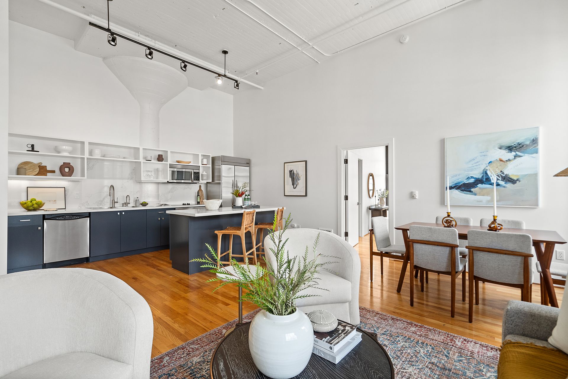 A living room filled with furniture and a table with a plant on it.