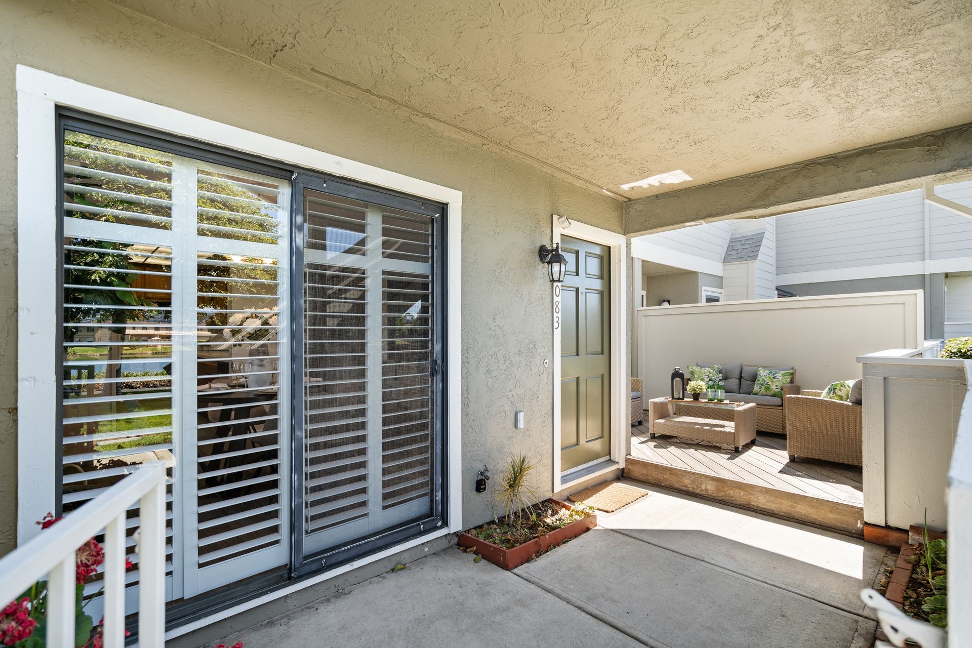 A patio with sliding glass doors and shutters