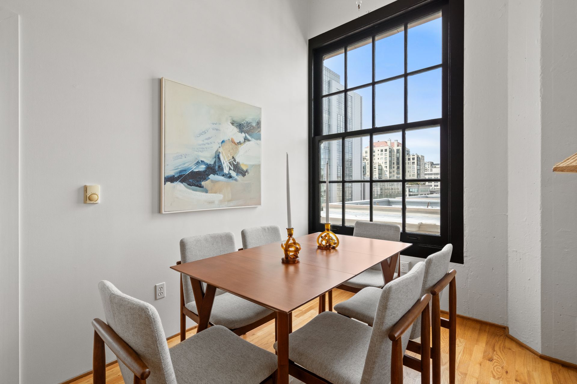 A dining room with a table and chairs and a window