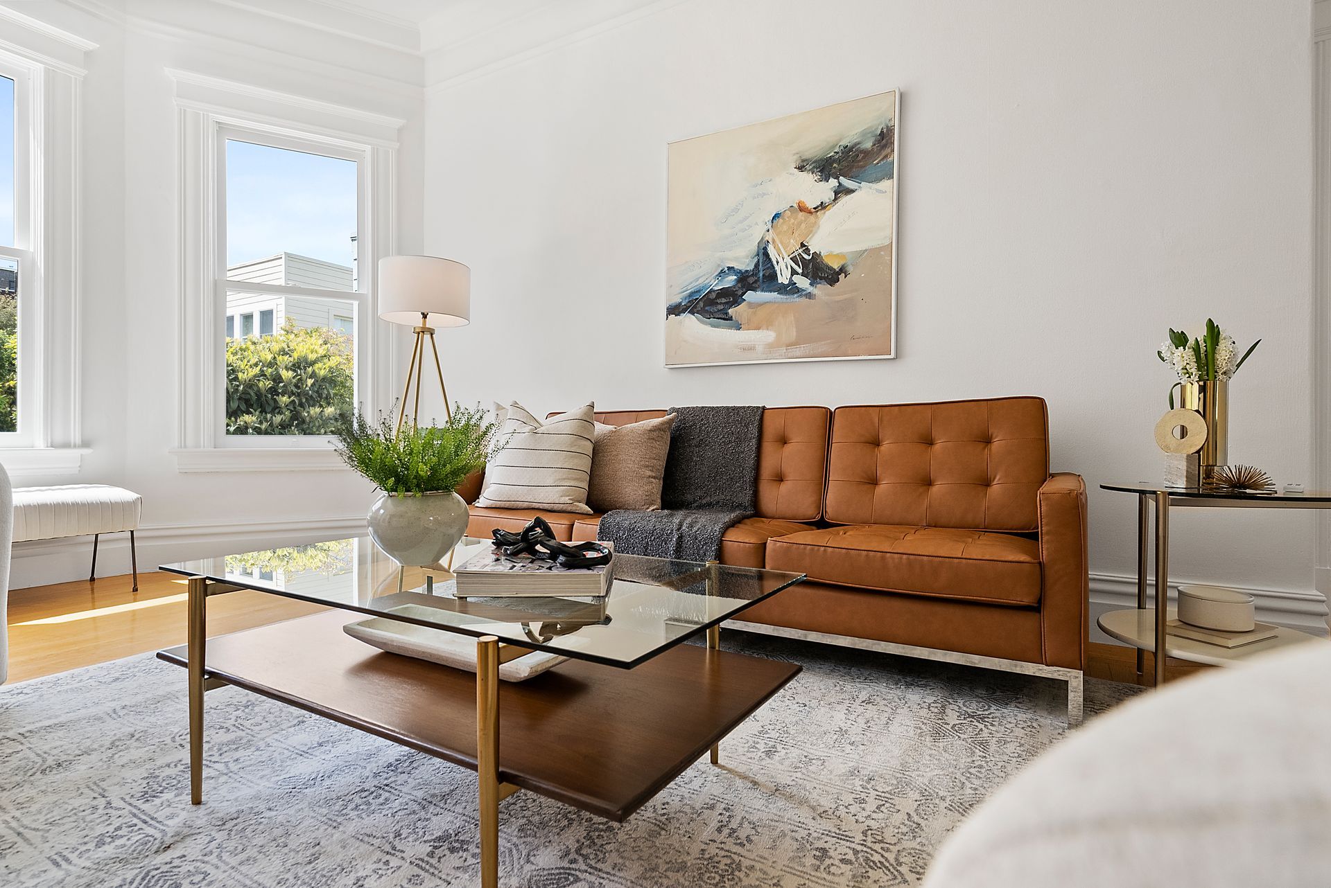 A living room with a brown couch and a glass coffee table.