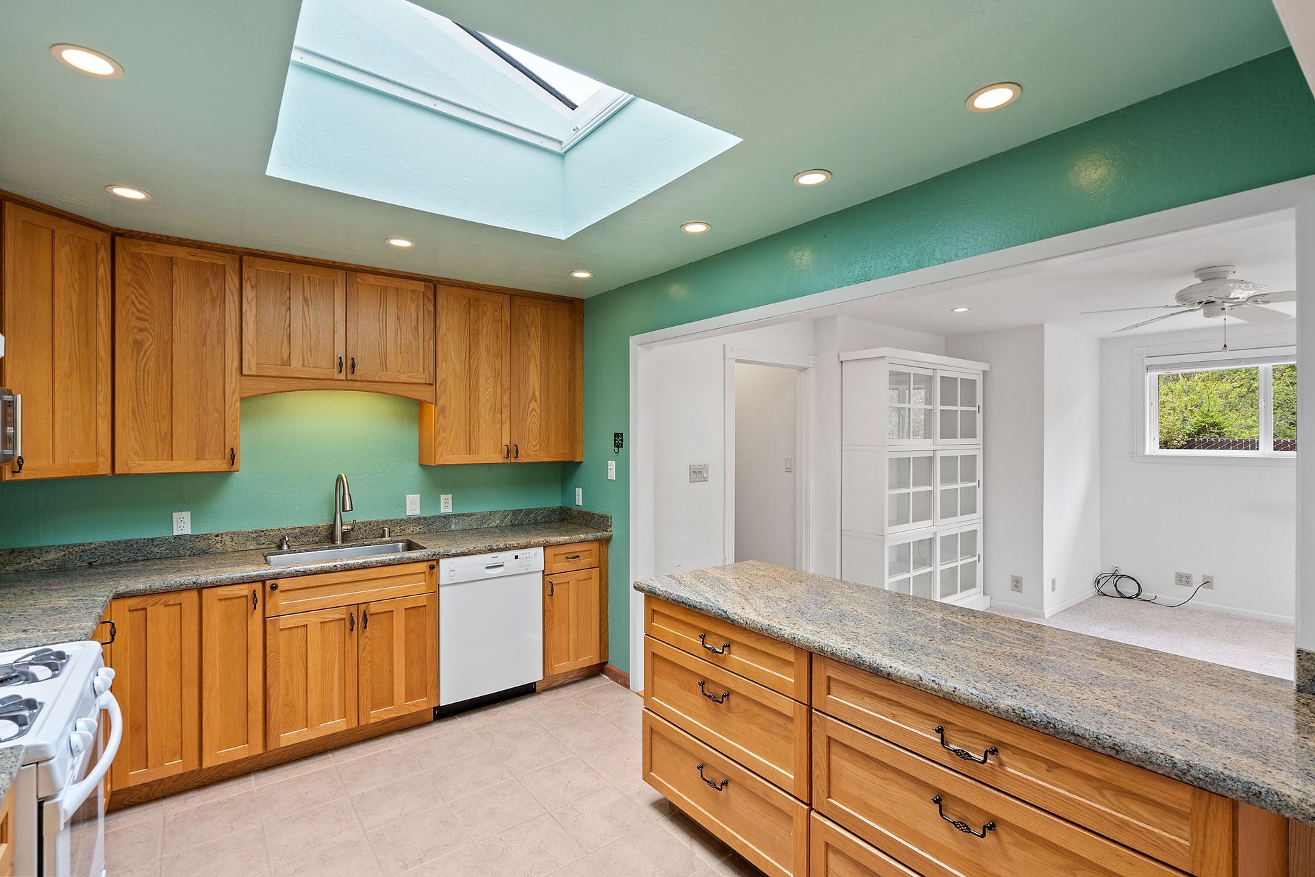 A kitchen with a skylight above the sink.