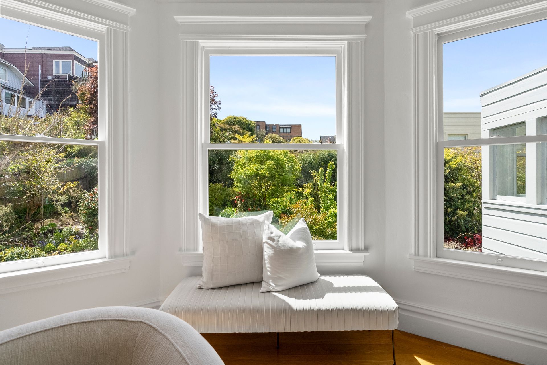 A living room with a couch , chair , and lots of windows.
