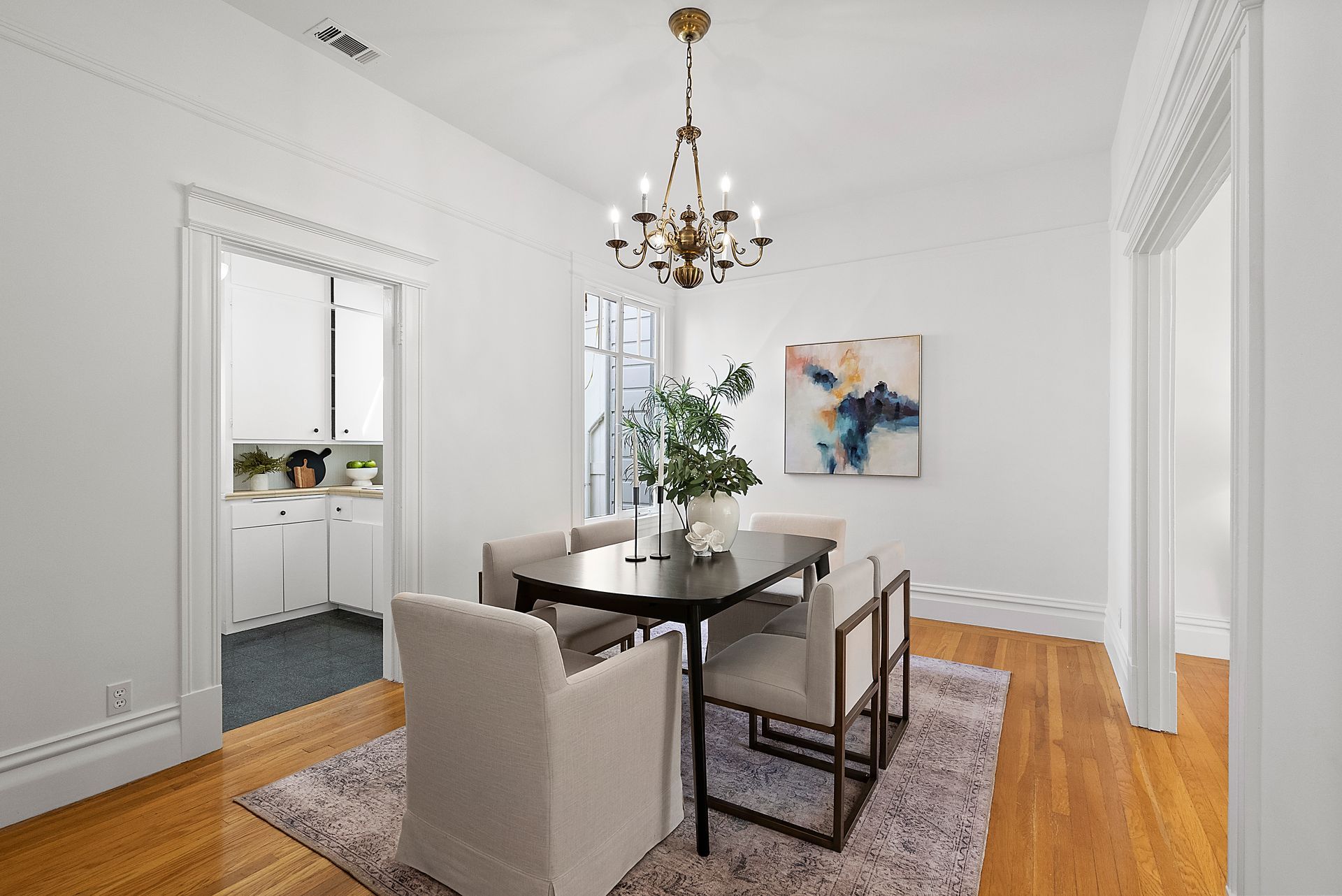 A dining room with a table and chairs and a chandelier.