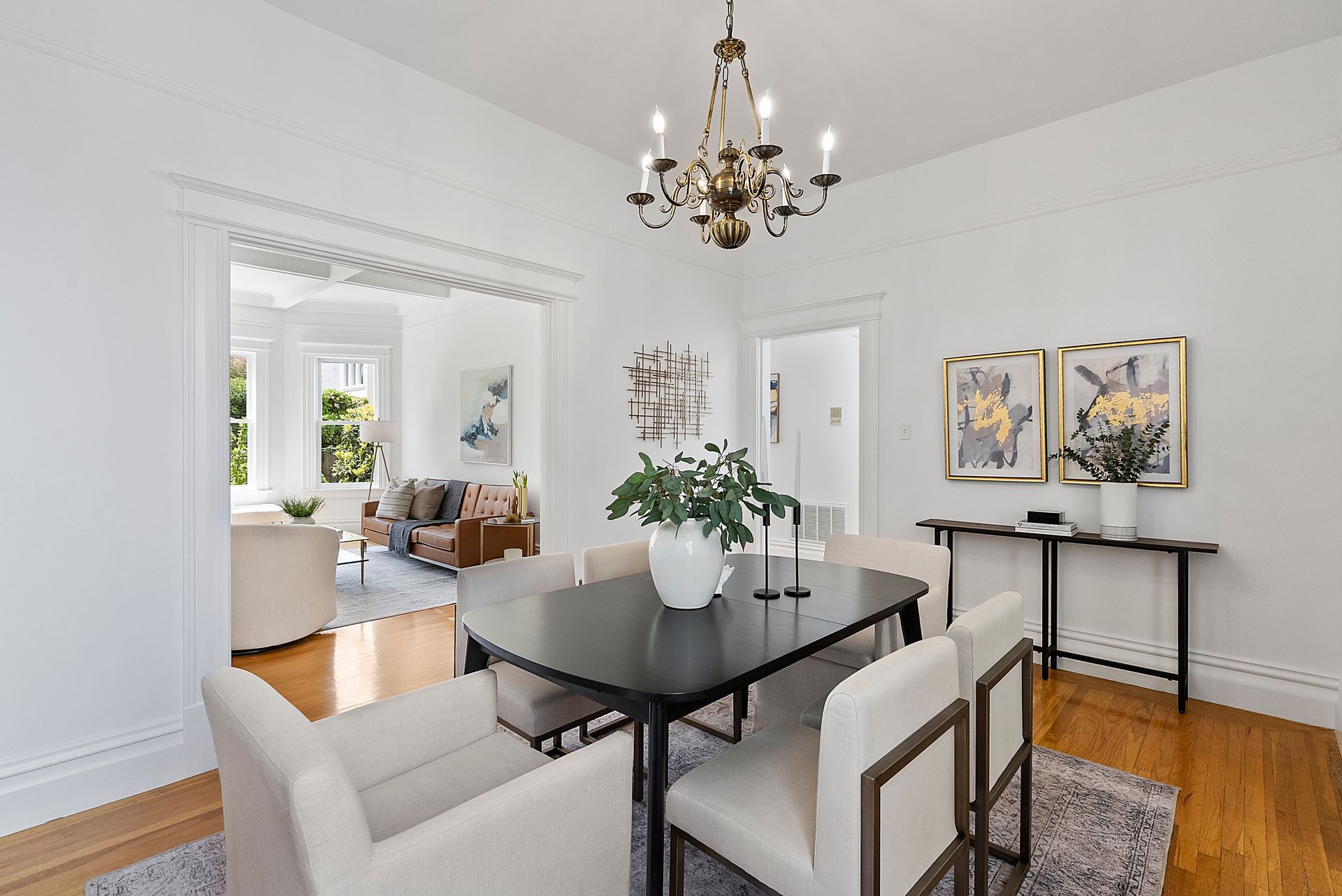 A dining room with a table and chairs and a chandelier.