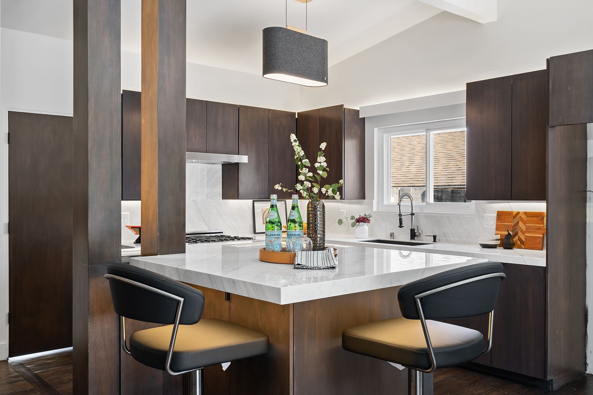 A kitchen with an island and two bar stools.
