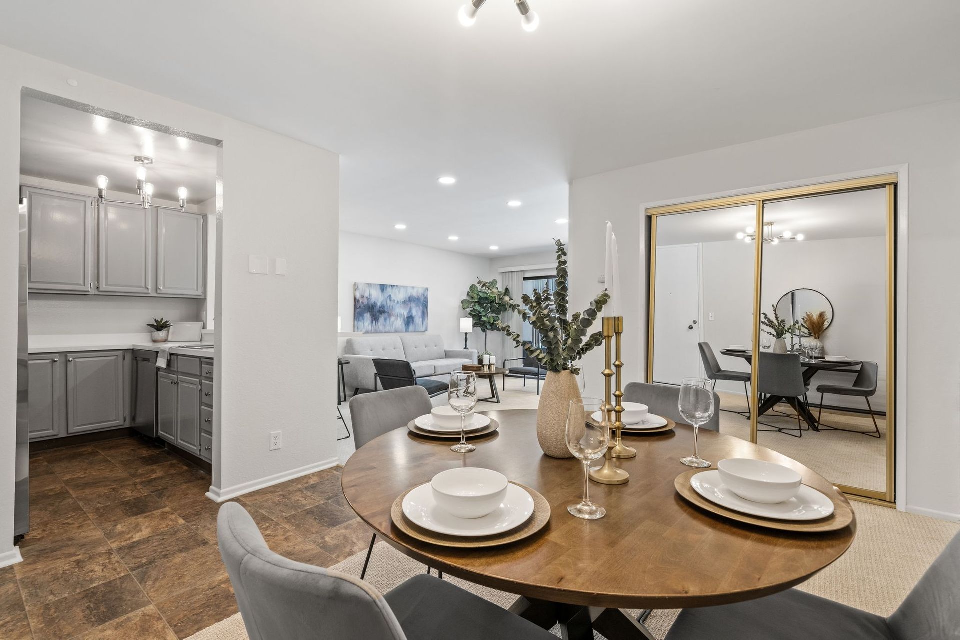 A dining room table with plates and glasses on it.