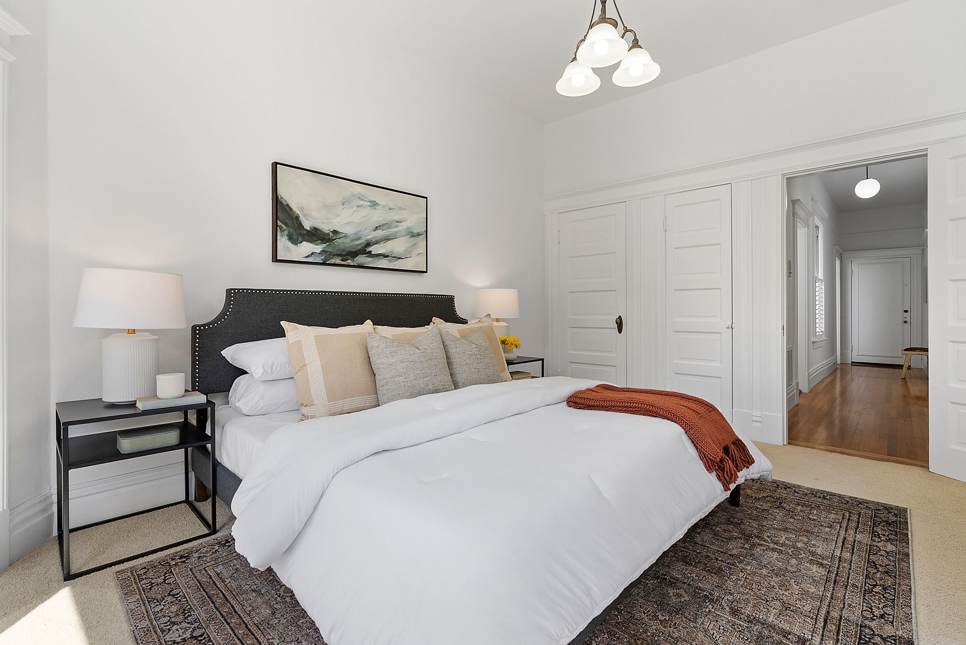 A bedroom with a bed and a rug.