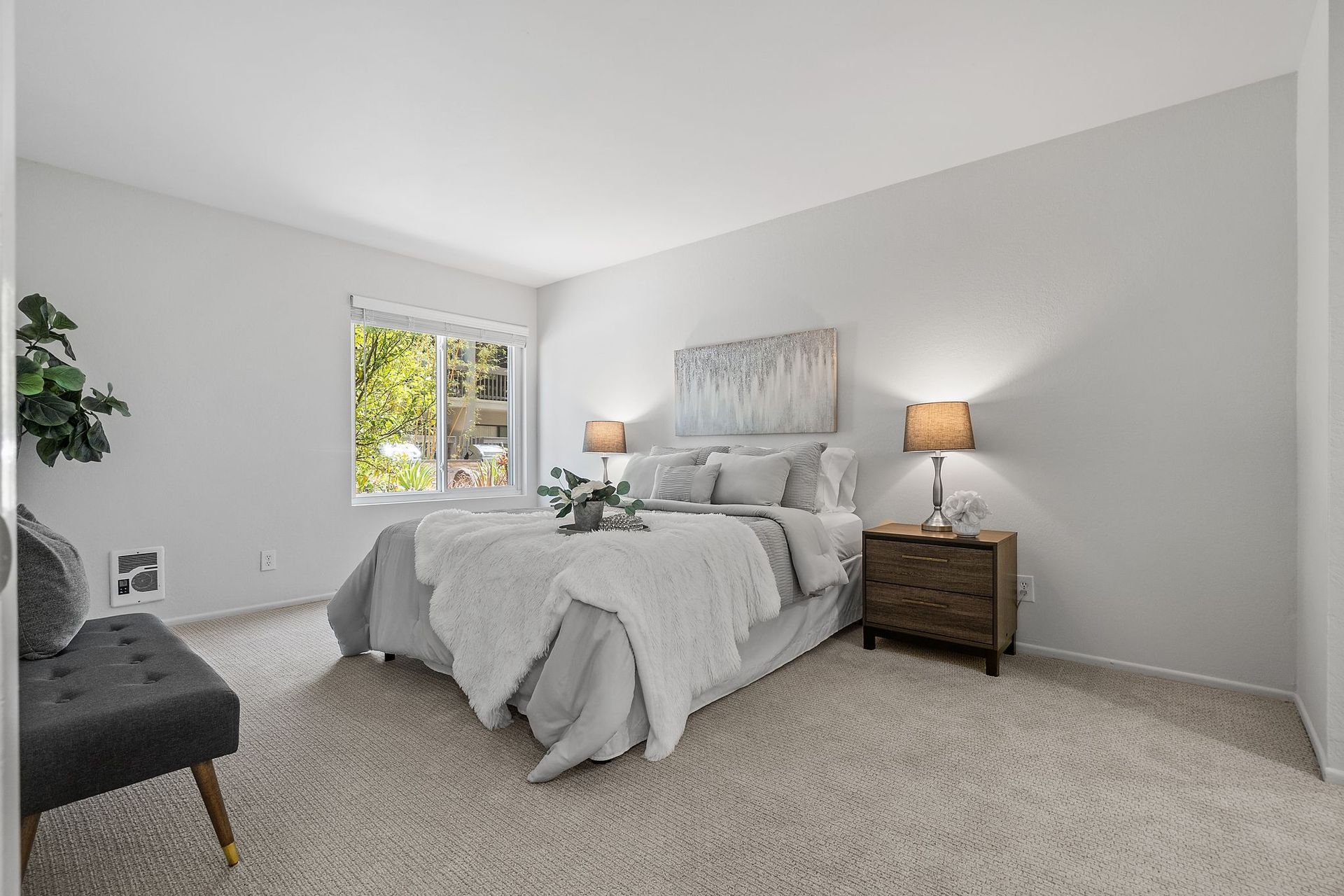 A bedroom with a bed , nightstand , chair and window.