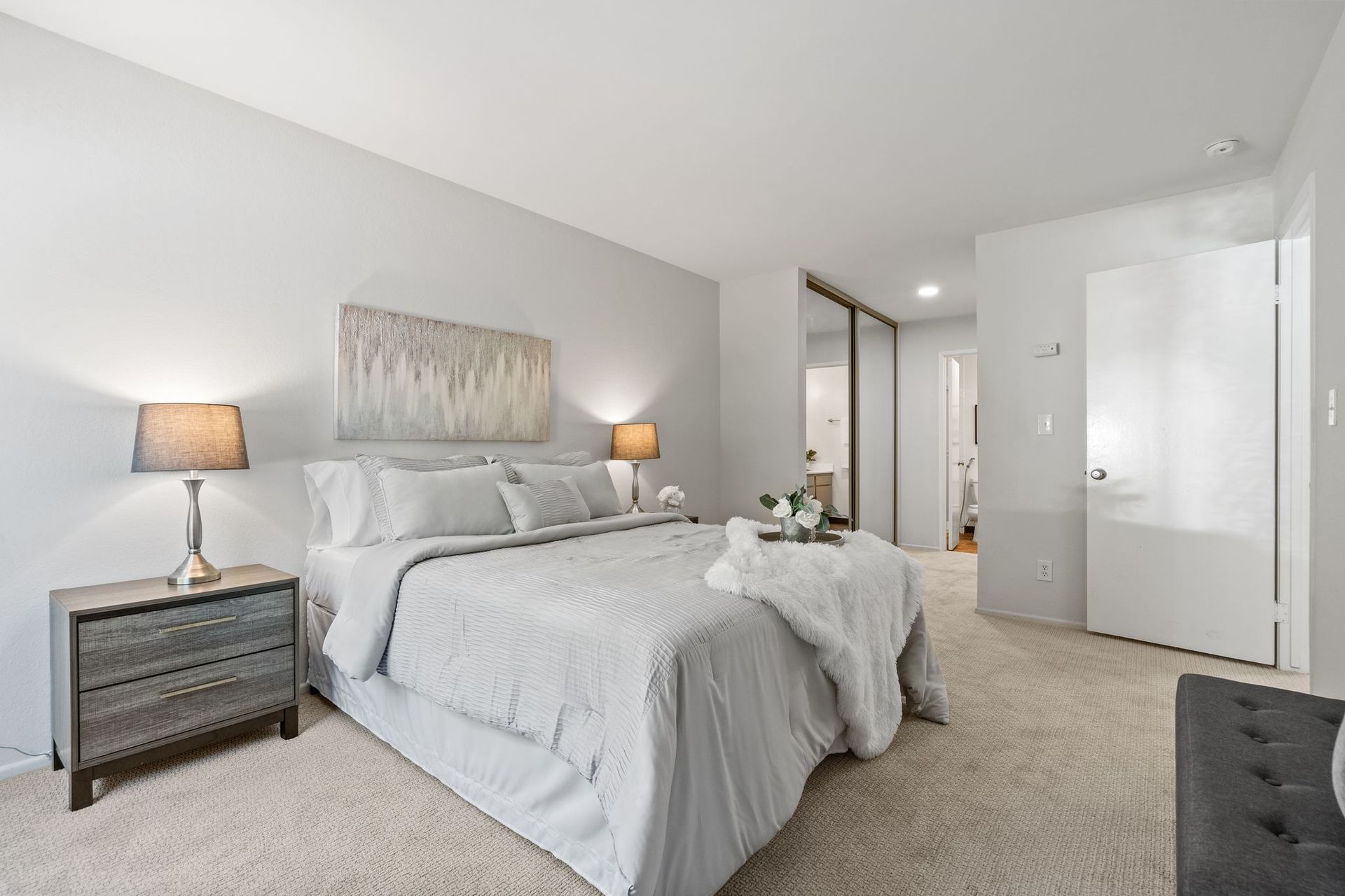 A bedroom with a bed , nightstand , and dresser.