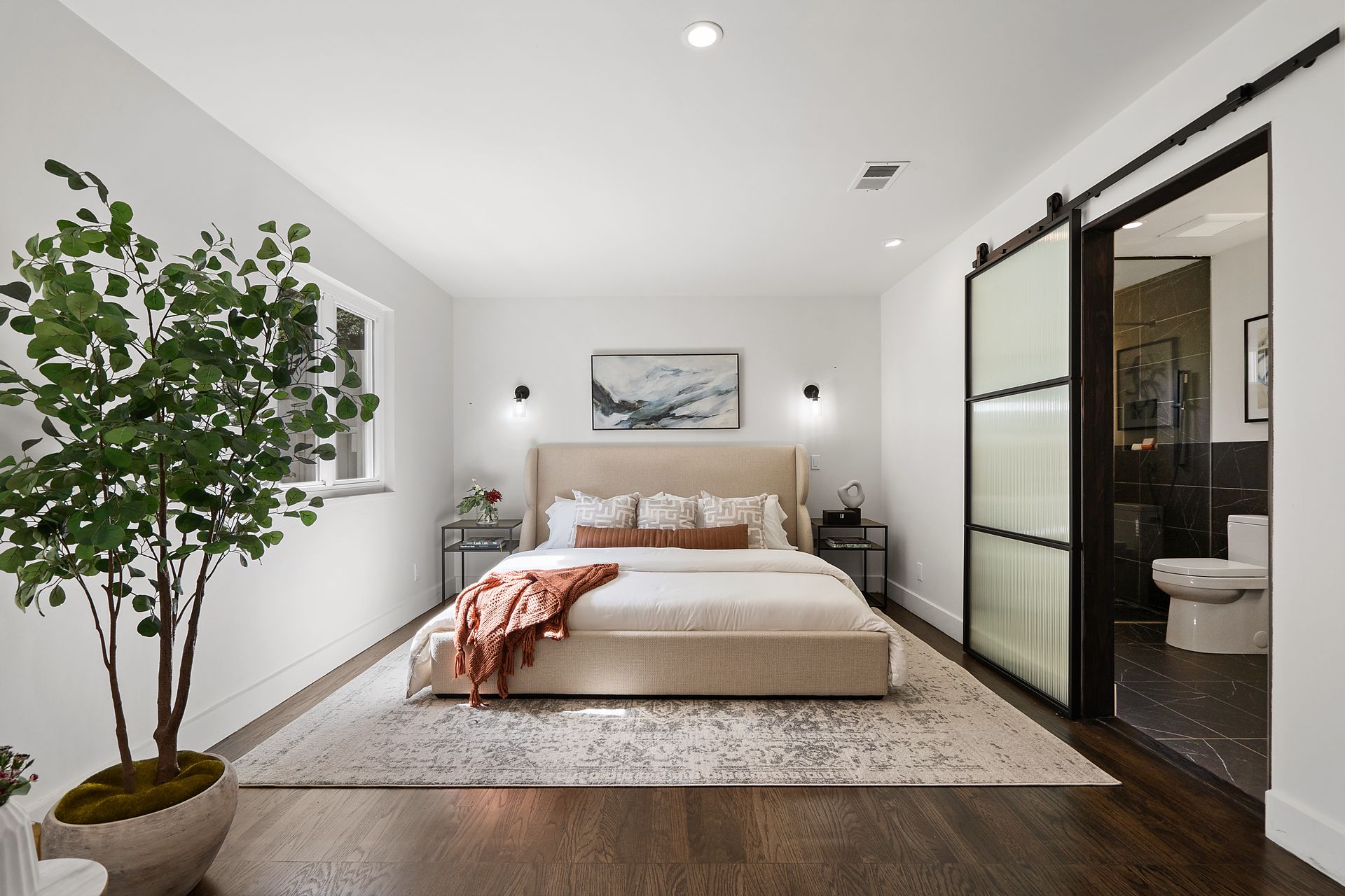 A bedroom with a bed and a sliding door.