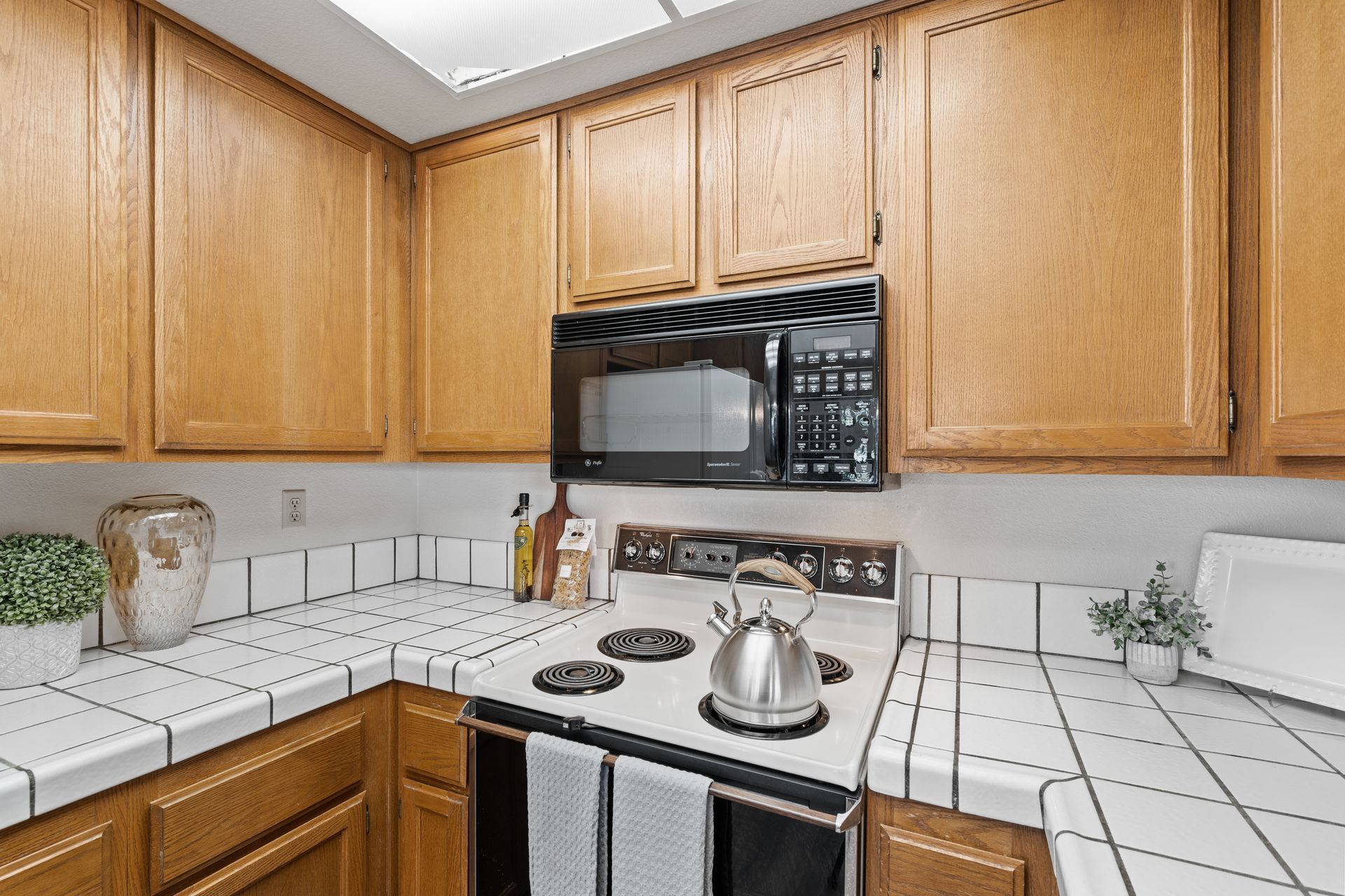 A kitchen with a stove , microwave , and wooden cabinets.