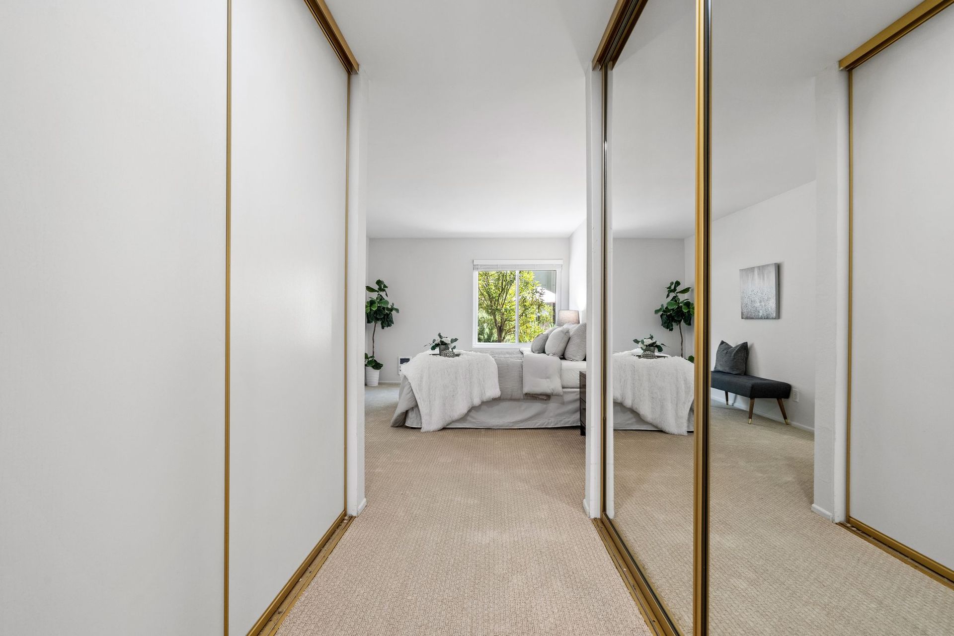 A hallway with sliding glass doors leading to a bedroom.