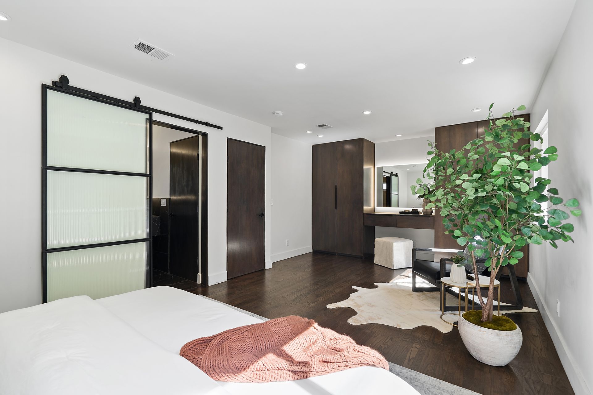 A bedroom with a bed and a sliding door.