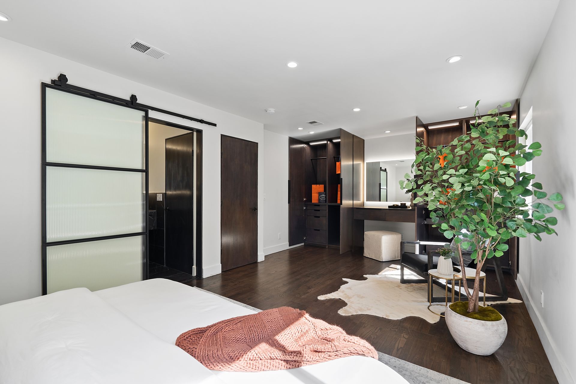 A bedroom with a bed and a sliding door.